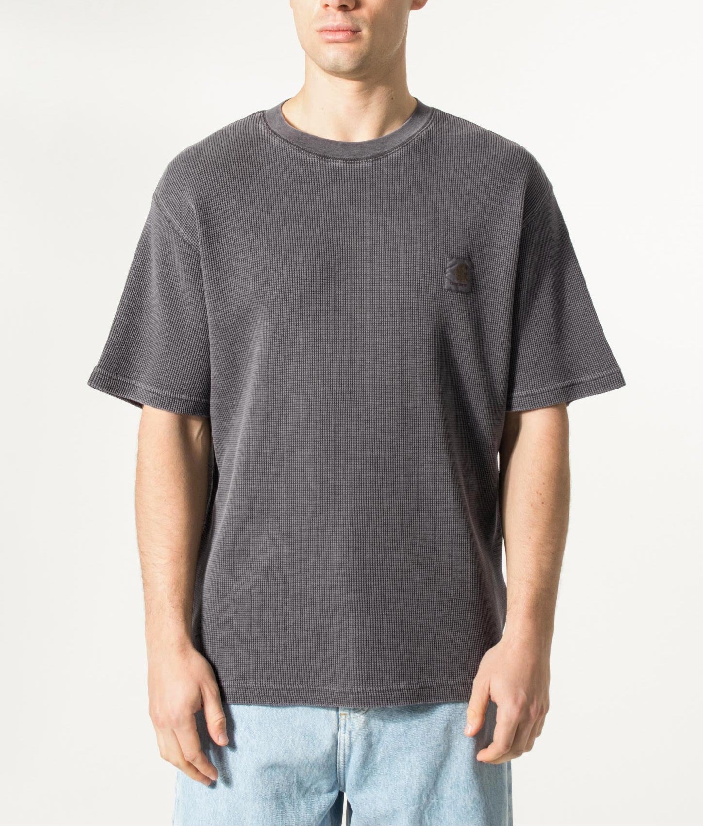 Carhartt WIP Relaxed Fit Nelson Waffle T-Shirt in Black at EQVVS Menswear. Model front shot.