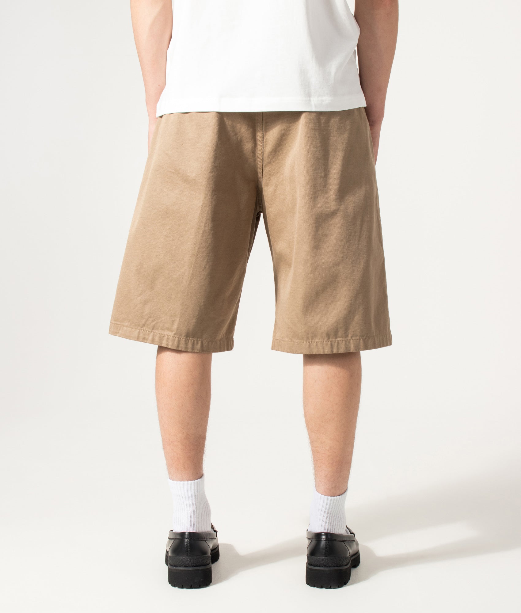 Carhartt WIP Loose Fit Brader Shorts in Rinsed Leather at EQVVS Menswear. Model back shot.