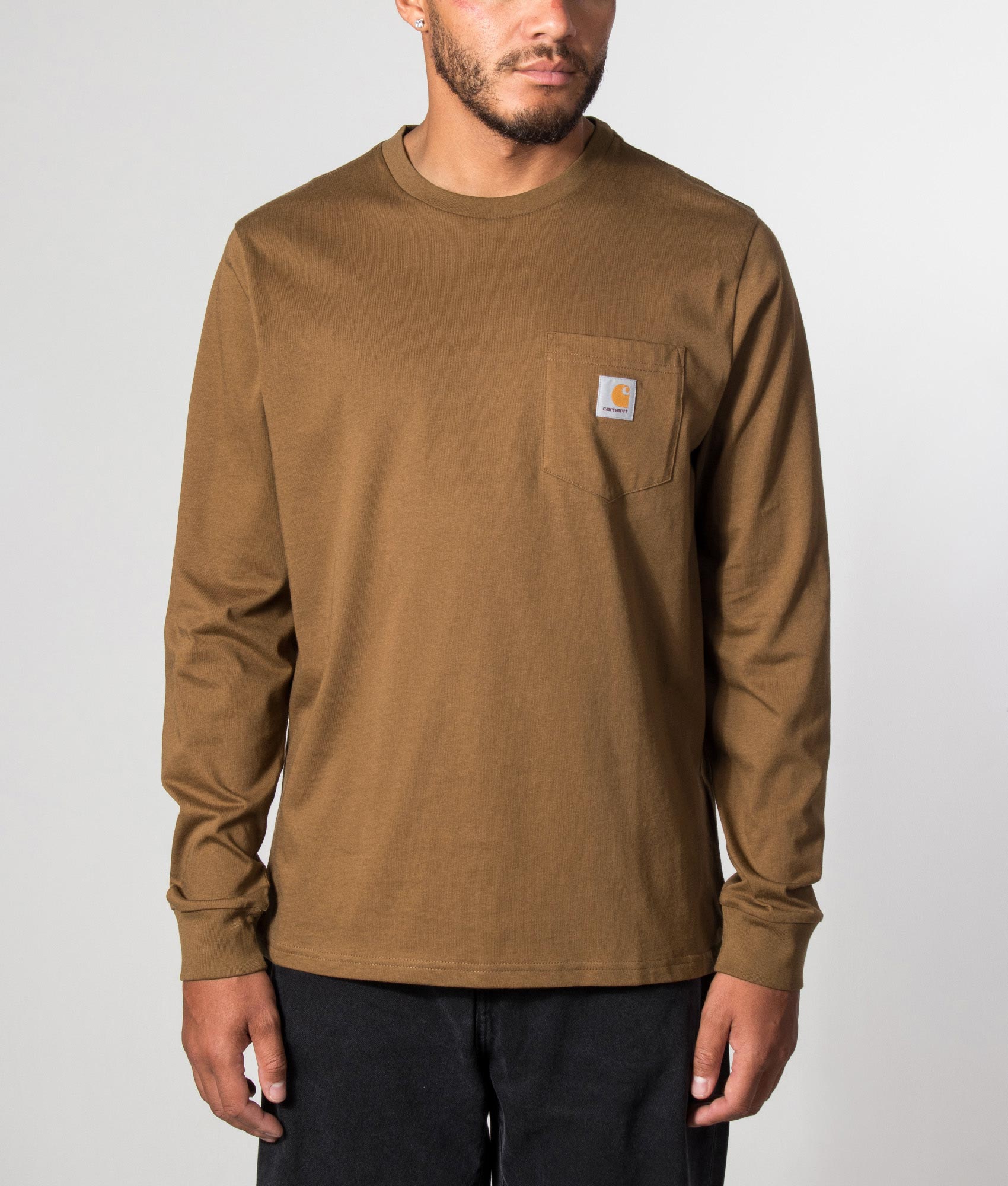Carhartt WIP Regular Fit Long Sleeve Pocket T-Shirt in WIP Hamilton Brown at EQVVS Menswear. Model front shot.