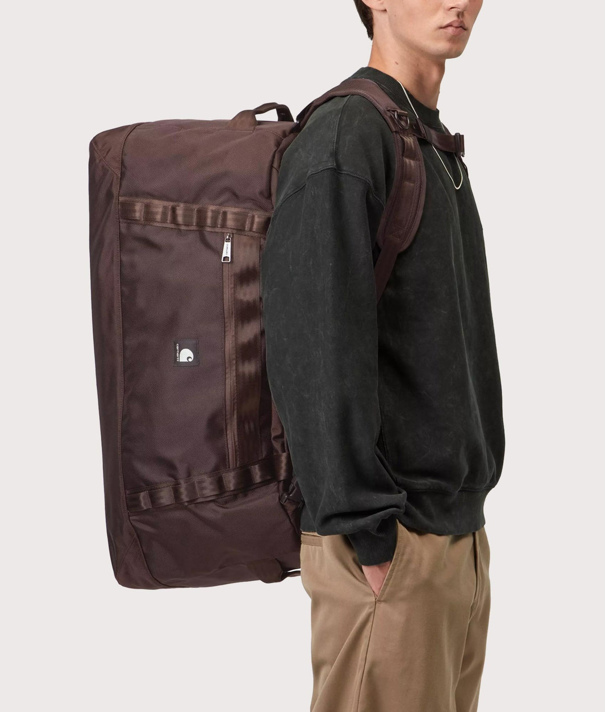 Carhartt WIP Richmond Large Duffle Bag in Palisander at EQVVS Menswear. Model front shot.