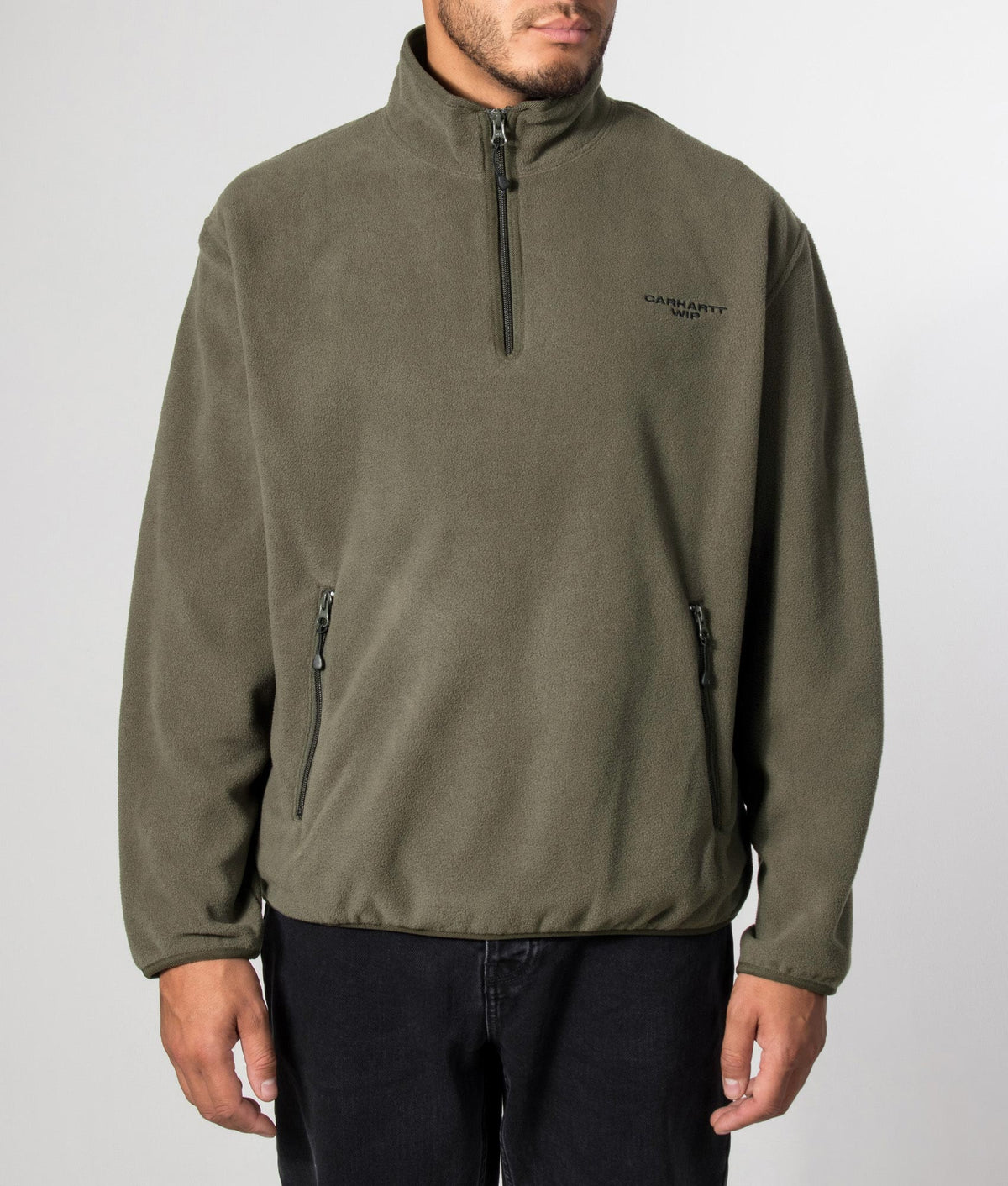 Carhartt WIP Balloon Fit Edmore Quarter Zip Fleece Sweatshirt in Cypress and Black at EQVVS Menswear. Model front shot.