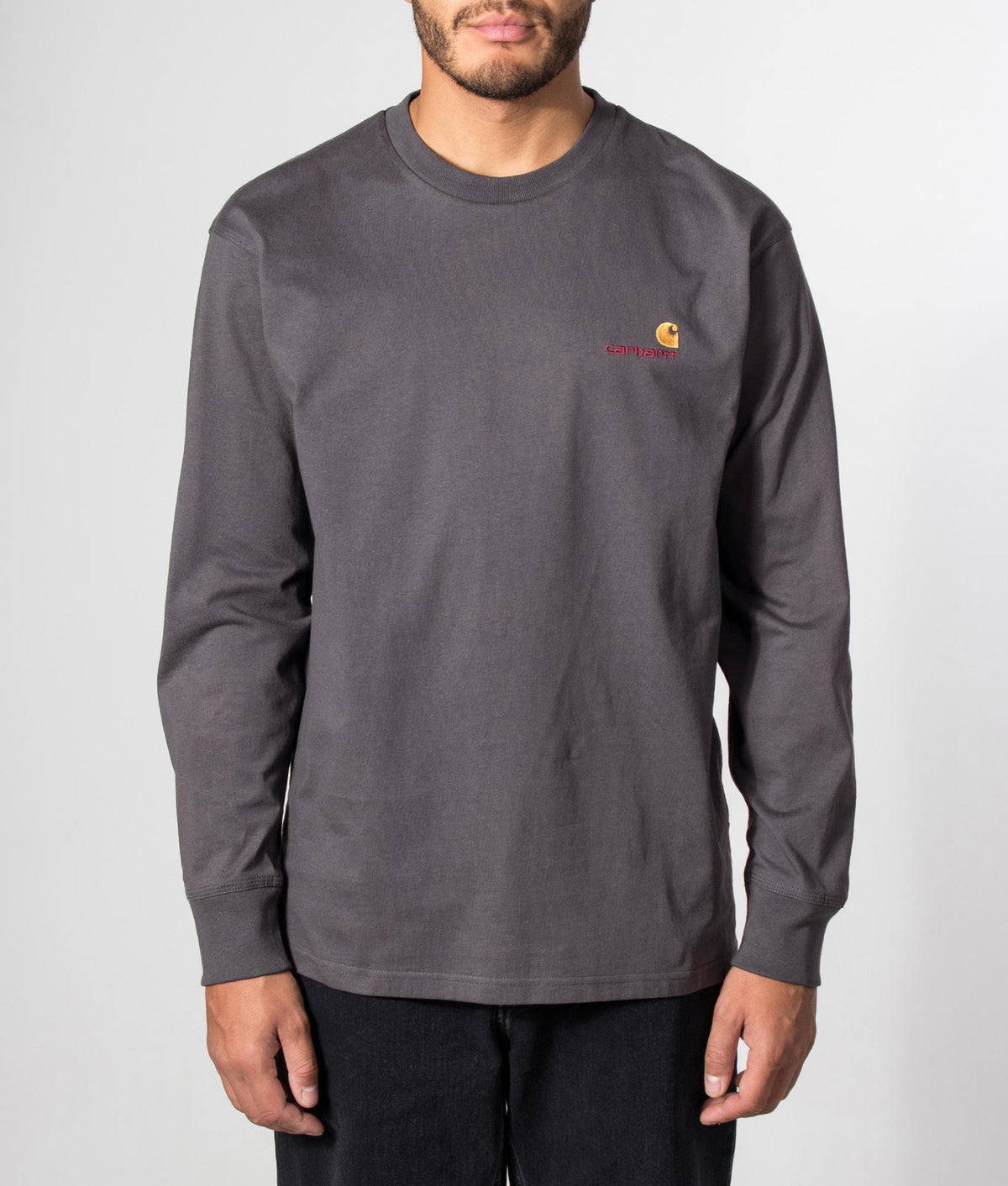 Carhartt WIP Loose Fit American Script Long Sleeve T-Shirt in Graphite at EQVVS Menswear. Model front shot.