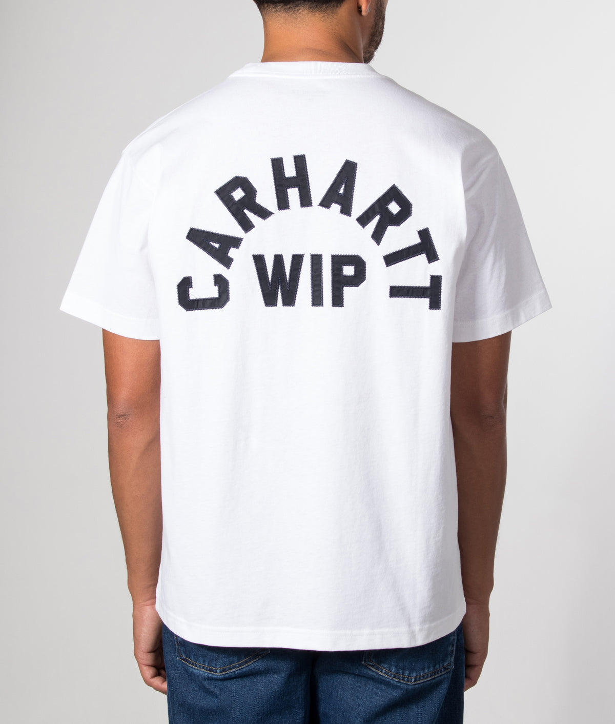 Carhartt WIP Loose Fit Arch Script T-Shirt in White and Dark Navy at EQVVS Menswear. Model back shot.