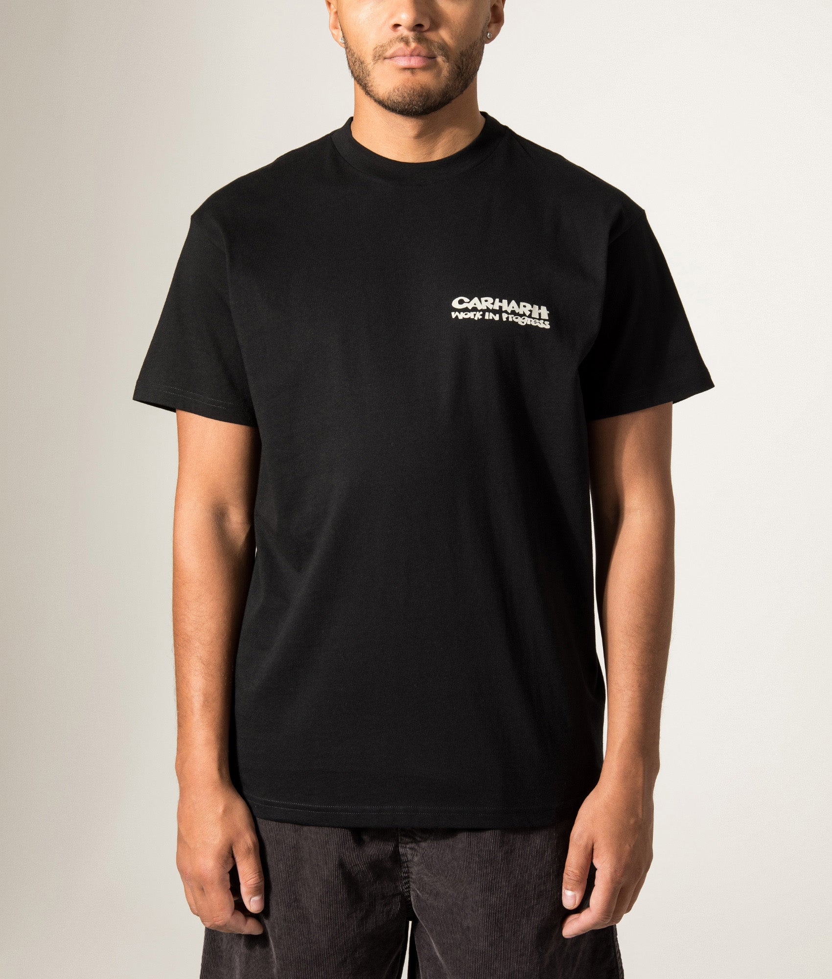 Carhartt WIP Loose Fit Cubist T-Shirt in Black at EQVVS Menswear. Model front shot.