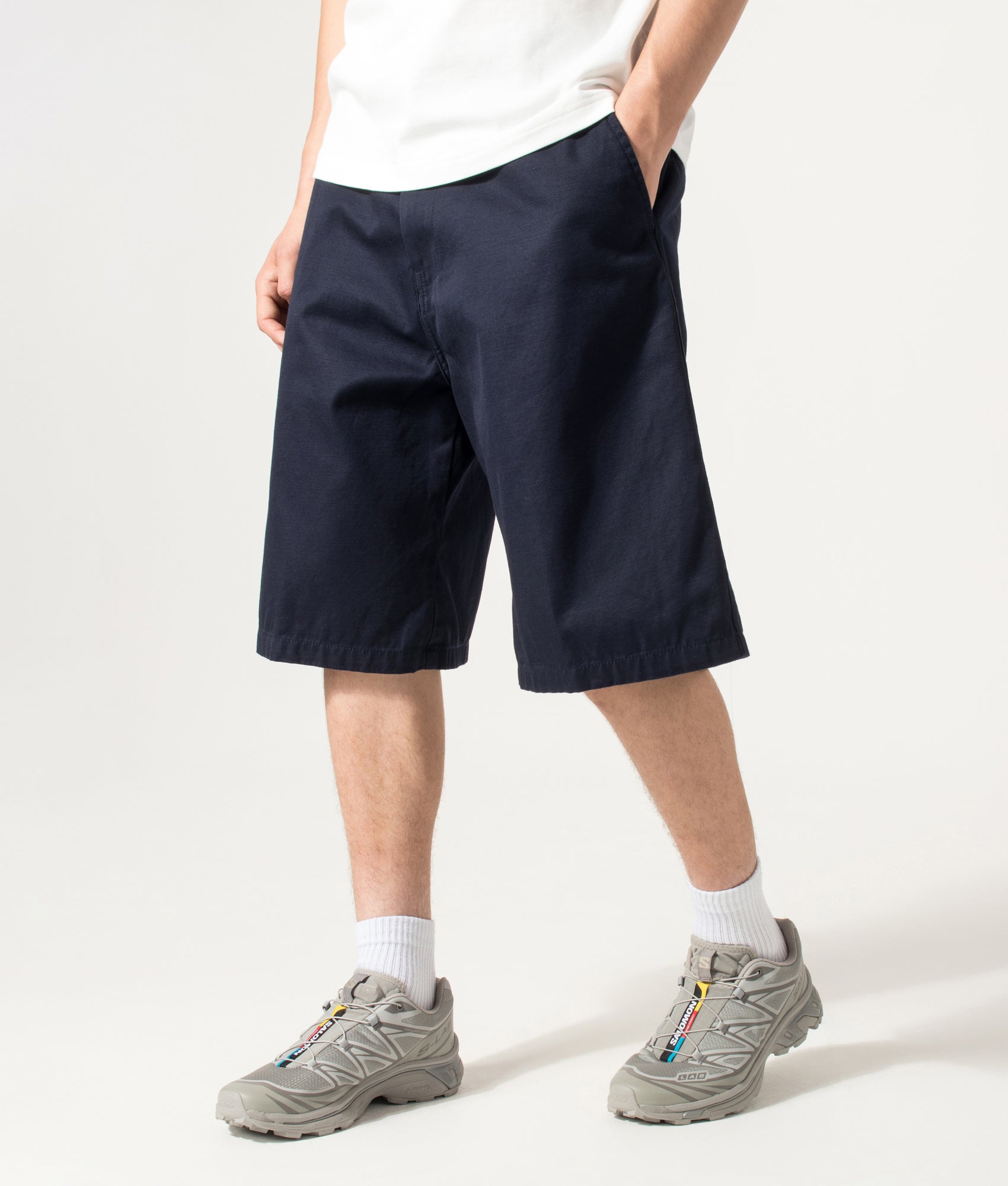 Carhartt WIP Loose Fit Brader Shorts in  Dark Navy at EQVVS Menswear. Angled model front shot.