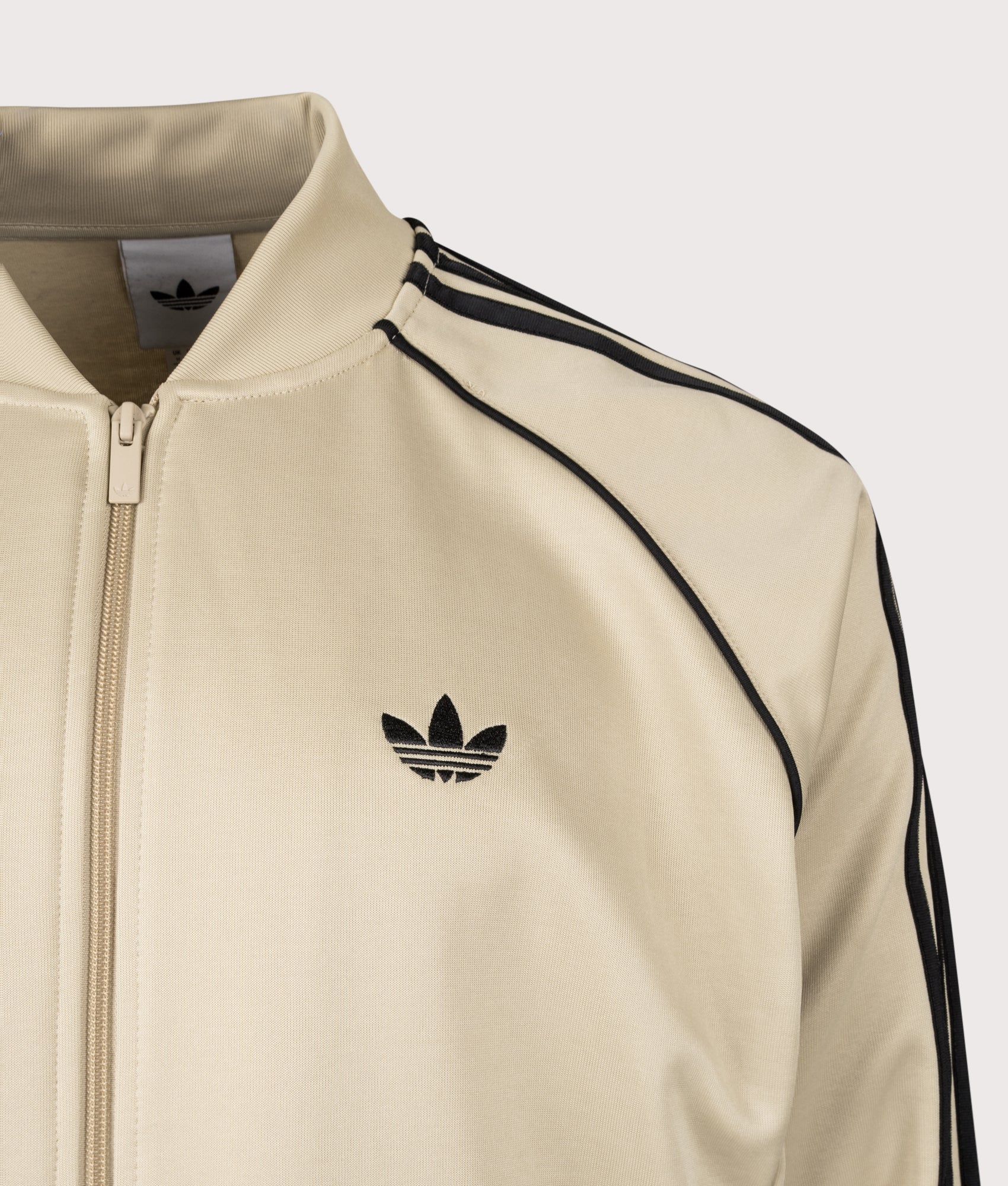 adidas Originals SST Track Top in Stone Khaki and Black at EQVVS Menswear. Detail shot.