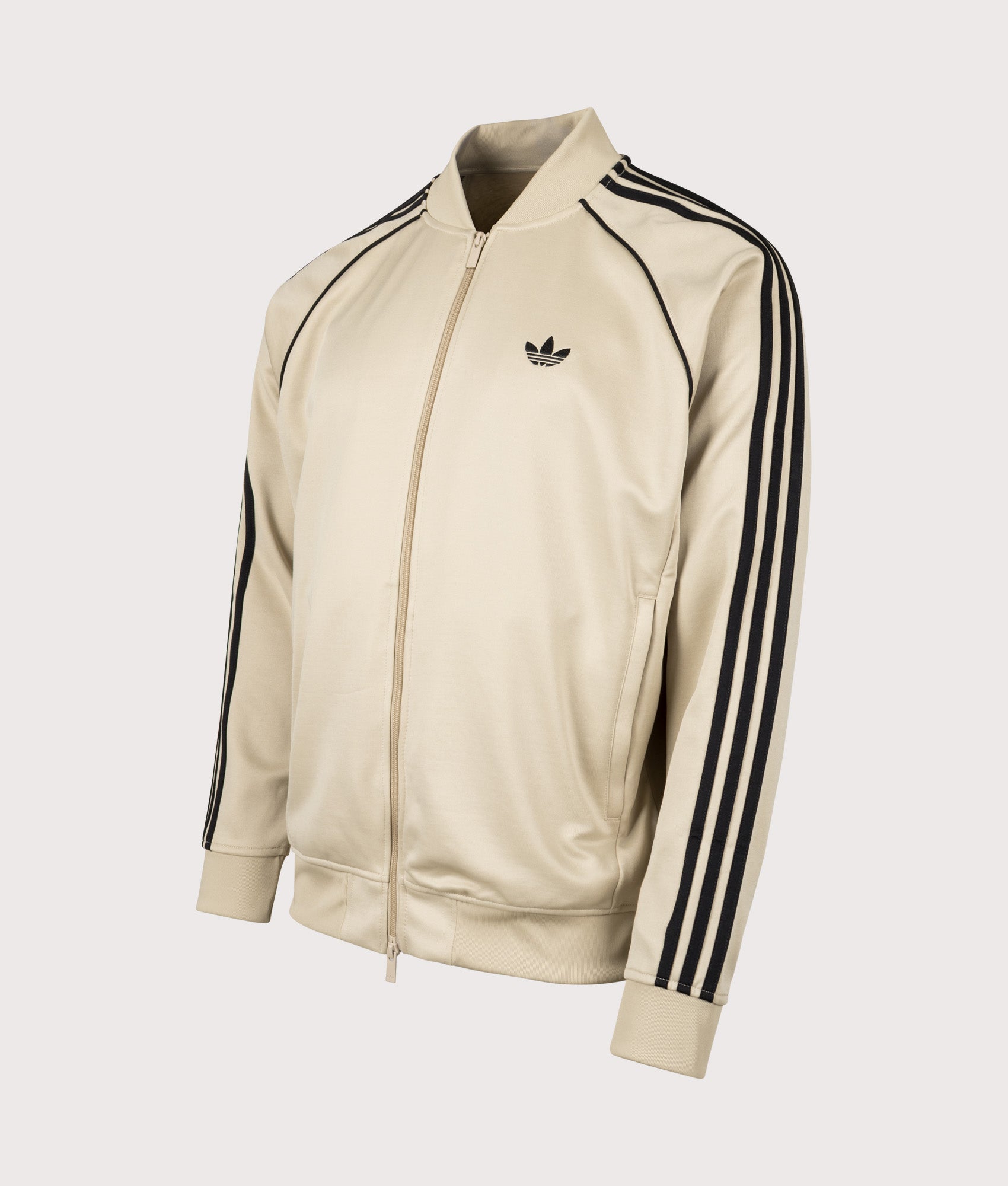 adidas Originals SST Track Top in Stone Khaki and Black at EQVVS Menswear. Angled front shot.
