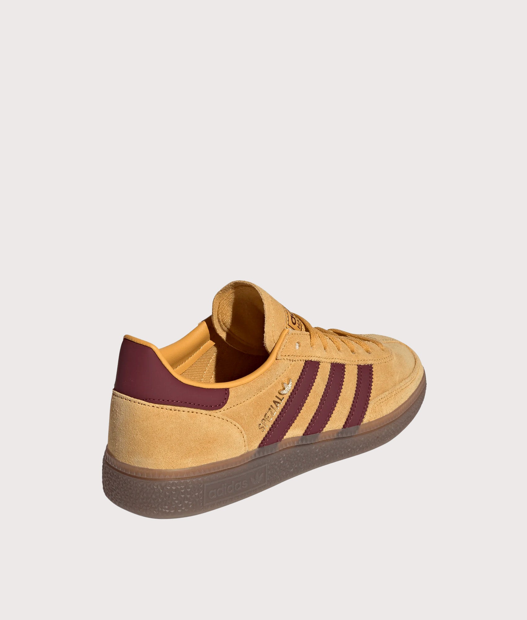 adidas Originals Handball Spezial Trainers in Preloved Yellow, Shadow Red and Gold Metallic at EQVVS Menswear. Angled back shot.