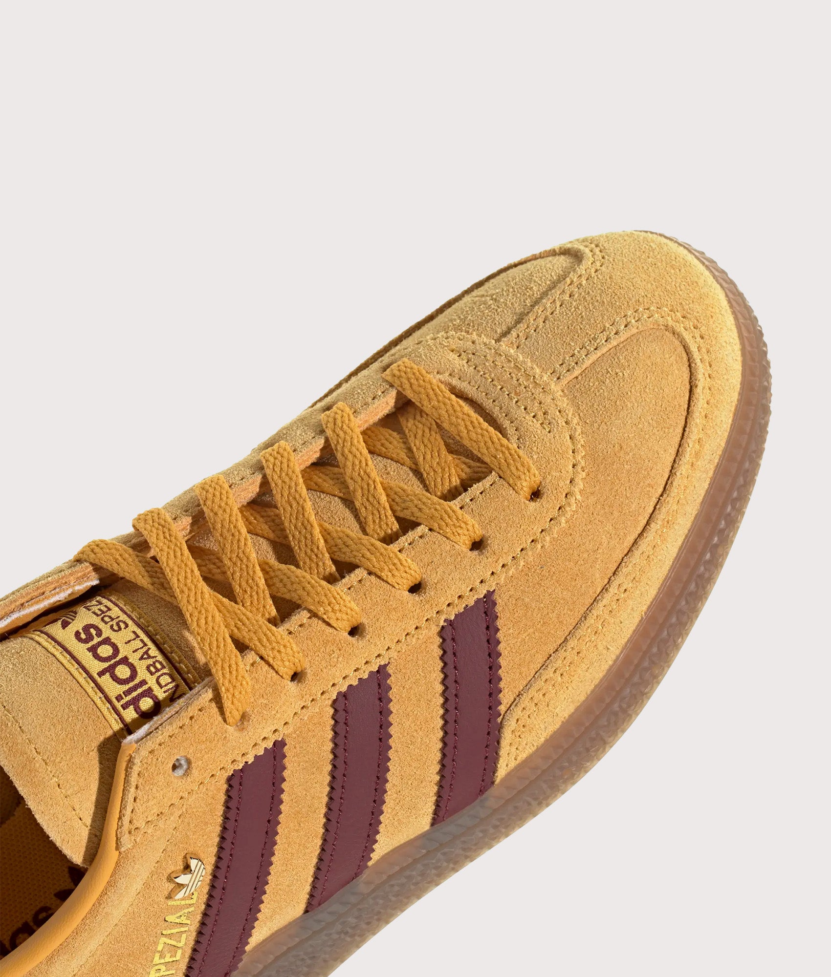 adidas Originals Handball Spezial Trainers in Preloved Yellow, Shadow Red and Gold Metallic at EQVVS Menswear. Detail shot.
