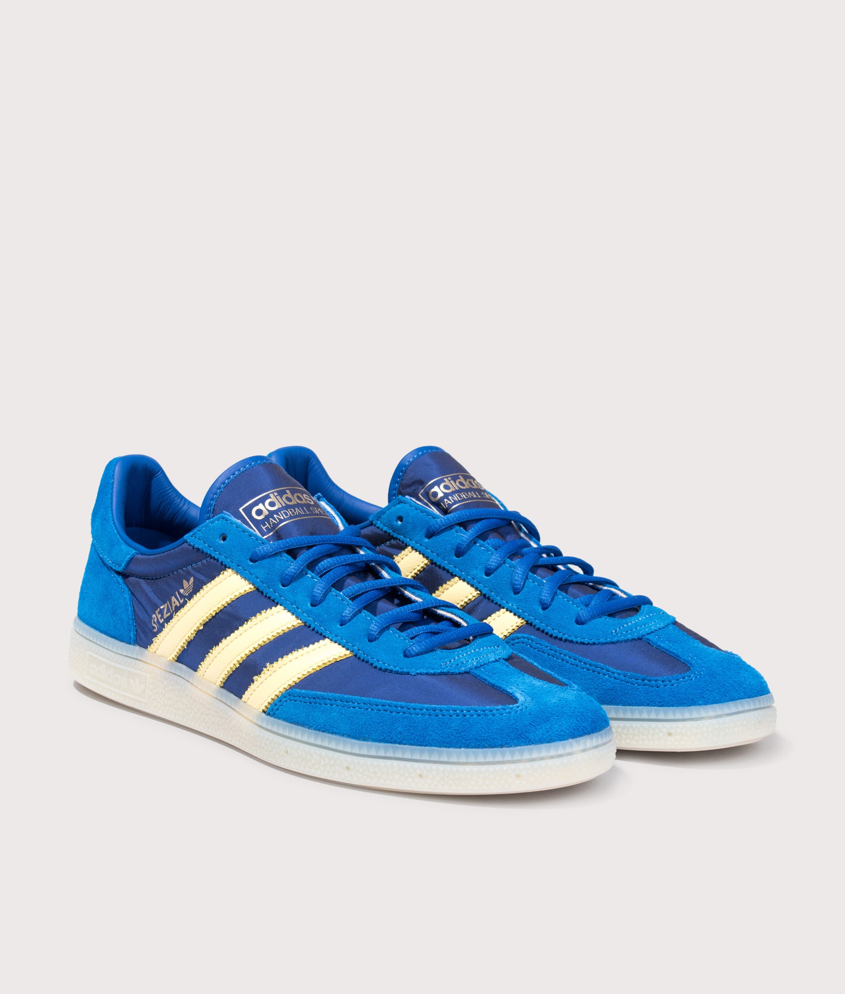 adidas Originals Handball Spezial Trainers in Equipment Blue, Almost Yellow and Off White at EQVVS Menswear. Angled front shot.