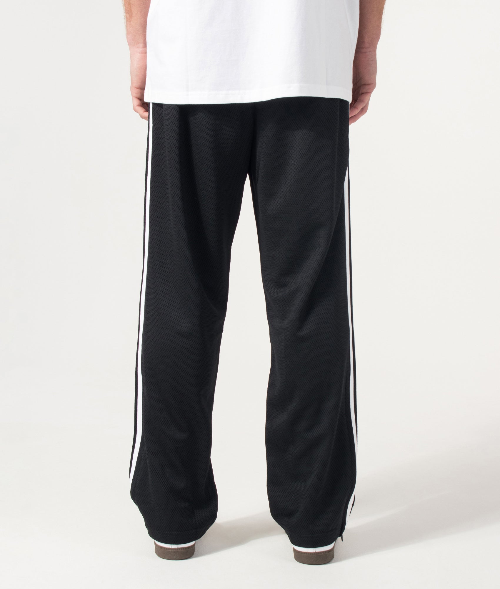 adidas Originals Firebird Track Pants in Black at EQVVS Menswear. Model back shot.
