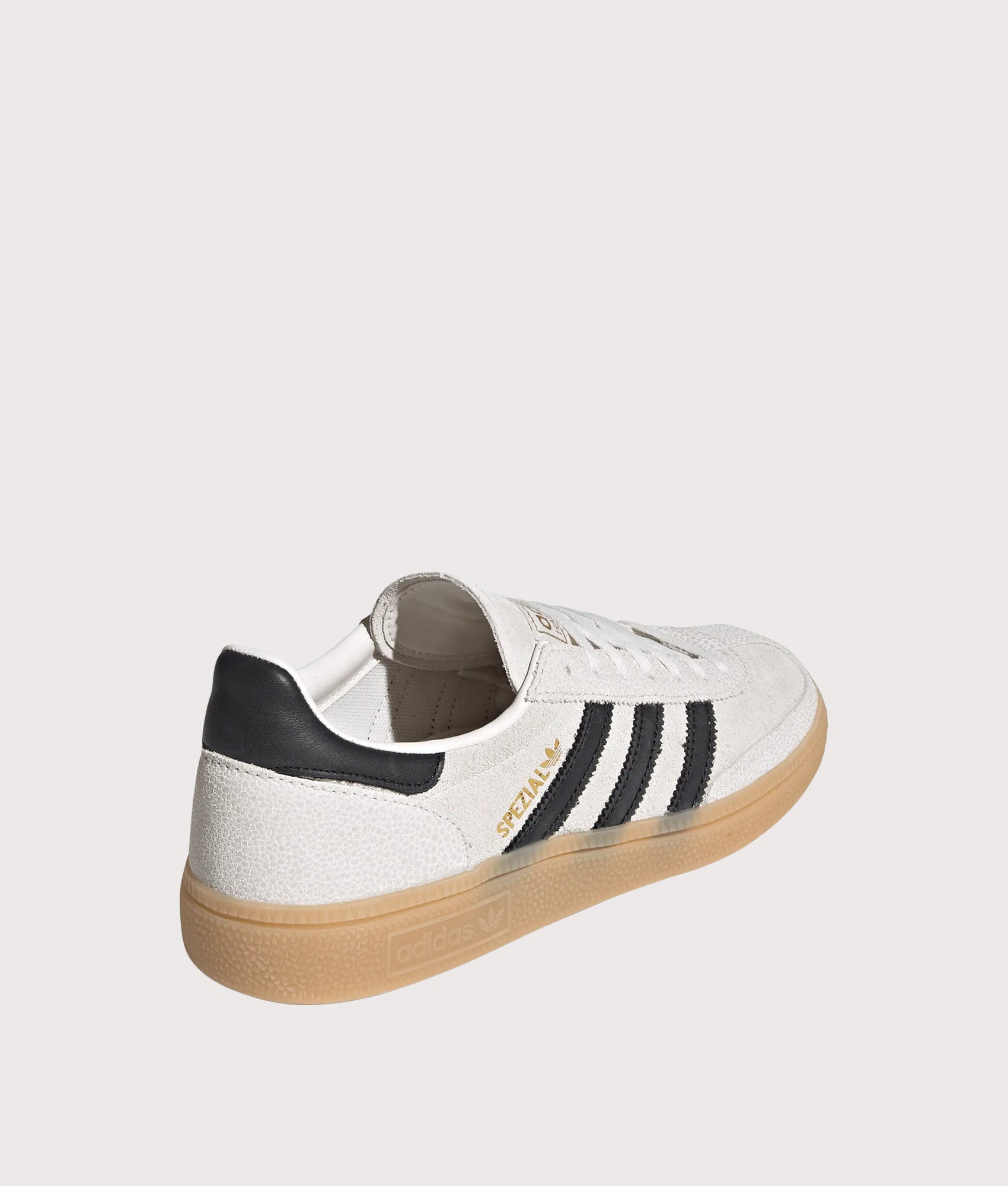 adidas Originals Handball Spezial Trainers in Cloud White, Core Black and Gold Metallic at EQVVS Menswear. Angled back shot.