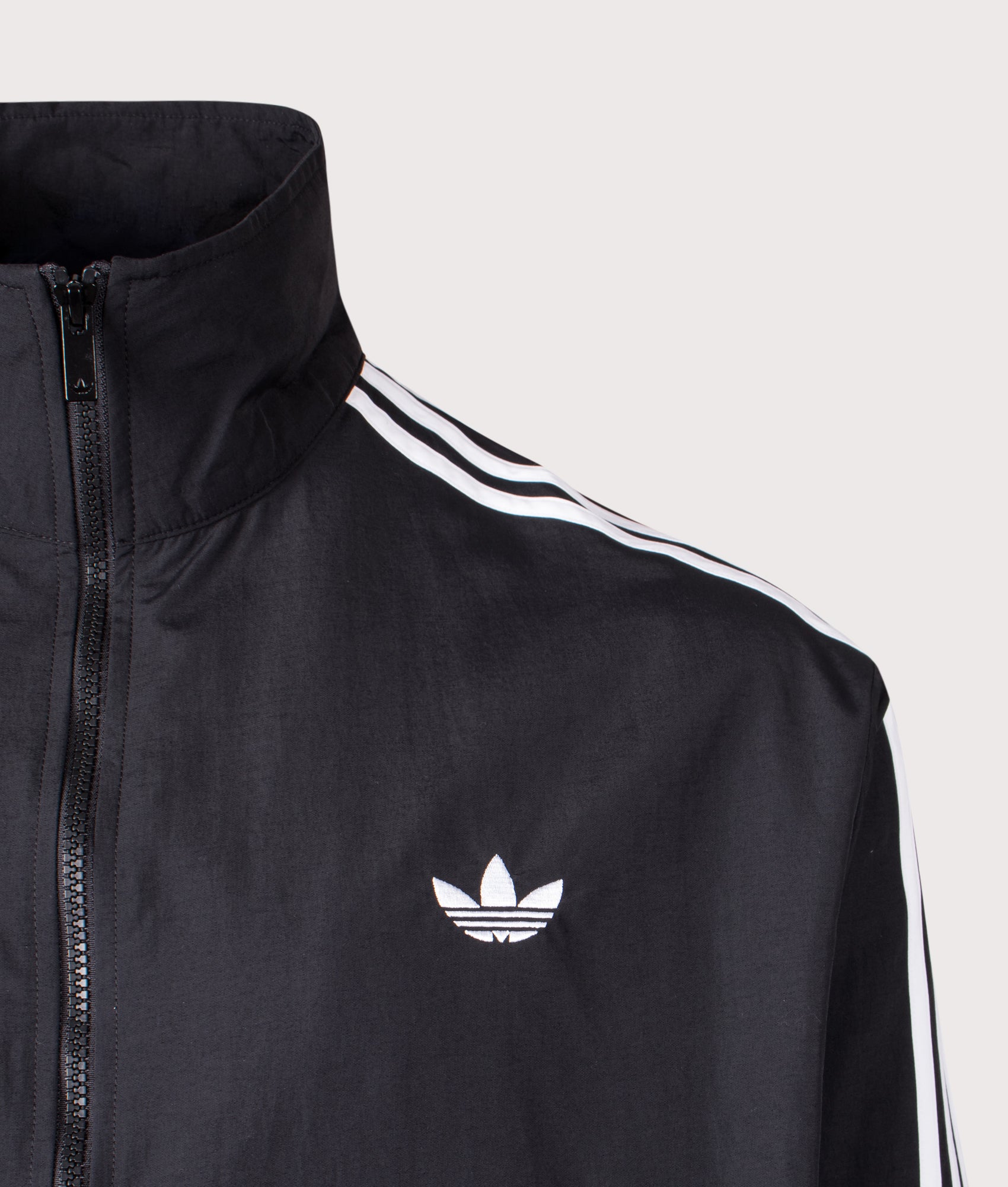 adidas Originals Loose Fit Firebird Woven Track Top in Black at EQVVS Menswear. Detail shot.