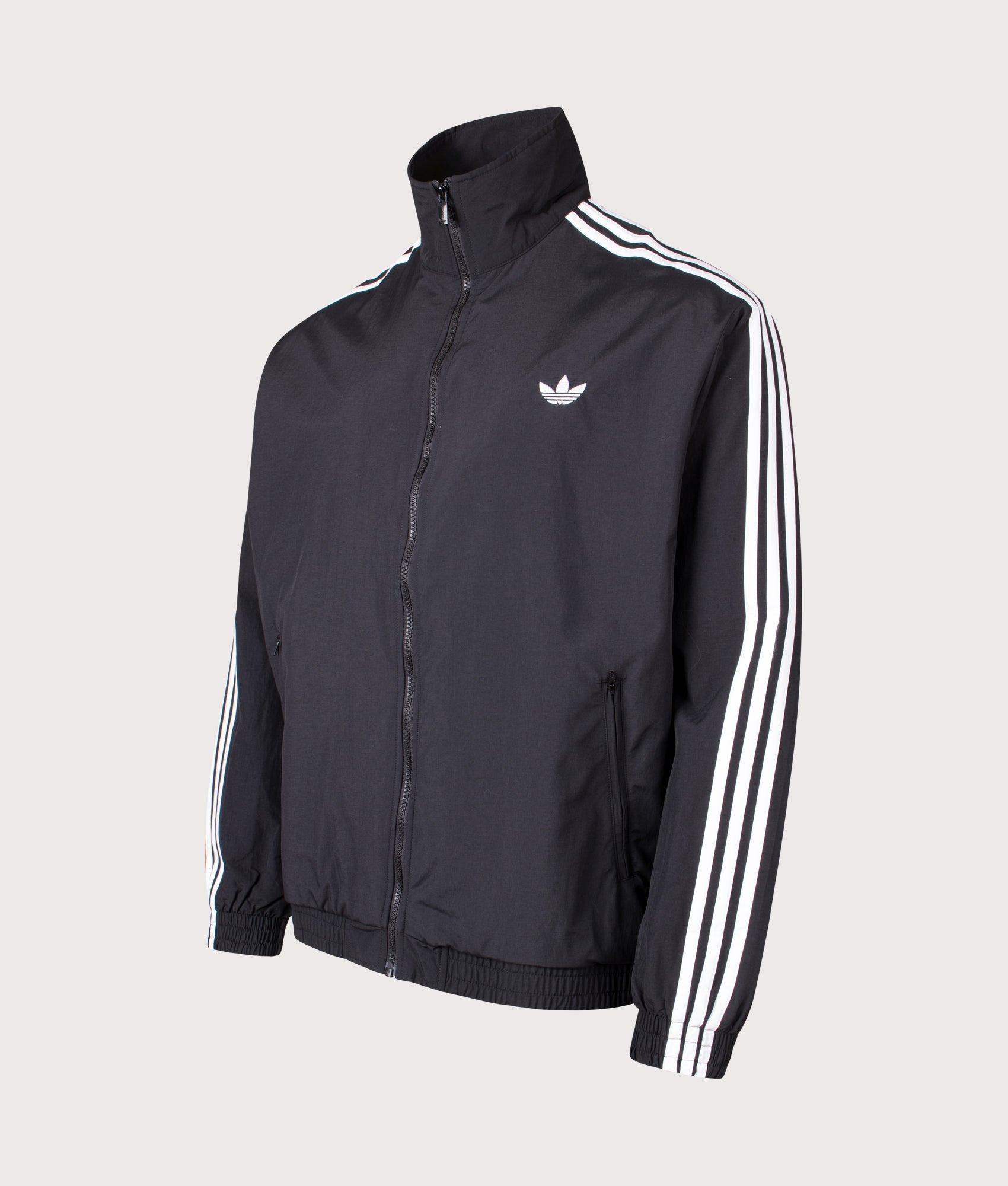 adidas Originals Loose Fit Firebird Woven Track Top in Black at EQVVS Menswear. Angled front shot.