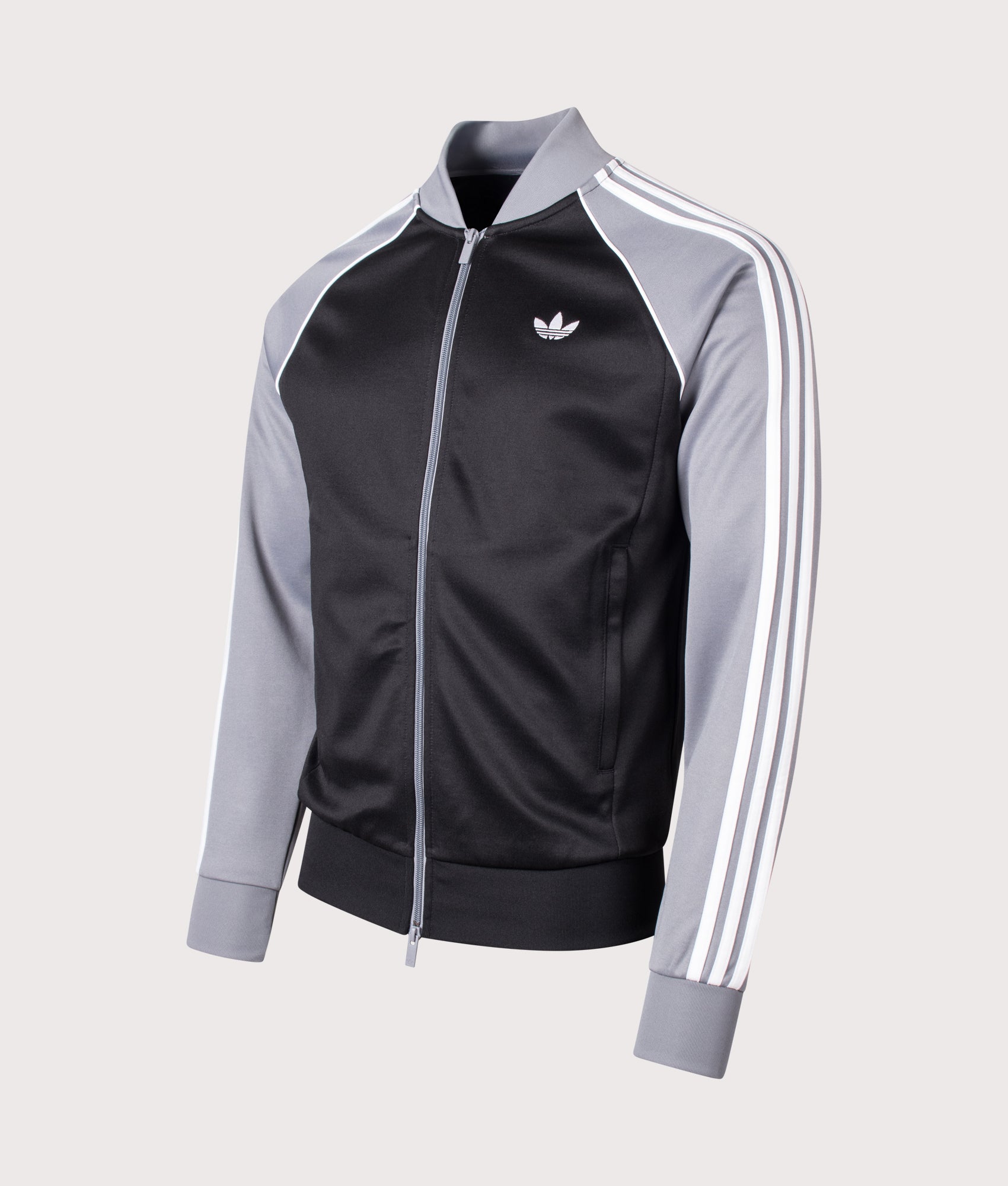 adidas Originals Slim Fit SST Track Top in Black, Grey and White at EQVVS Menswear. Angled front shot.