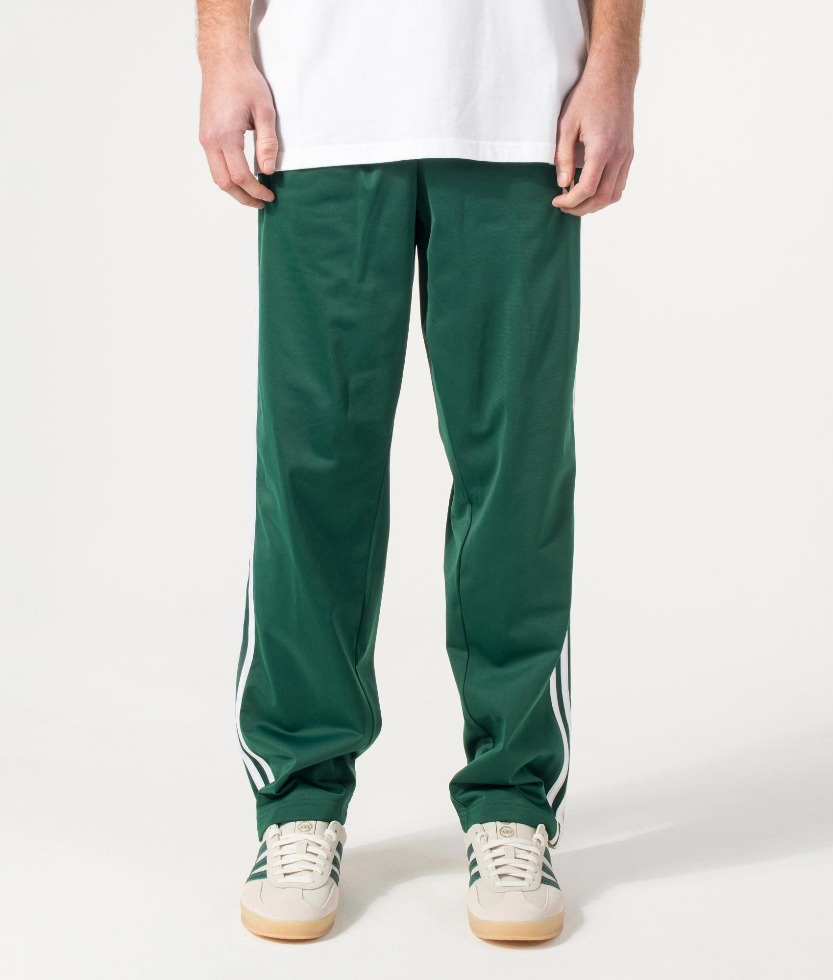 adidas Originals Firebird Track Pants in Collegiate Green at EQVVS Menswear. Model front shot.