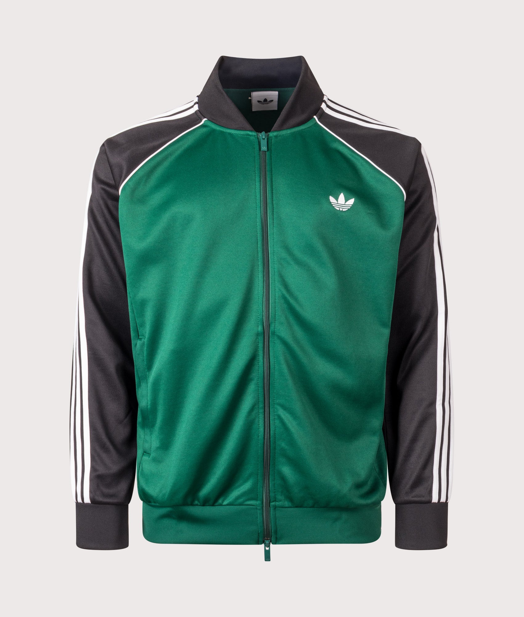 adidas Originals SST Track Top in Collegiate Green at EQVVS Menswear. Front shot.