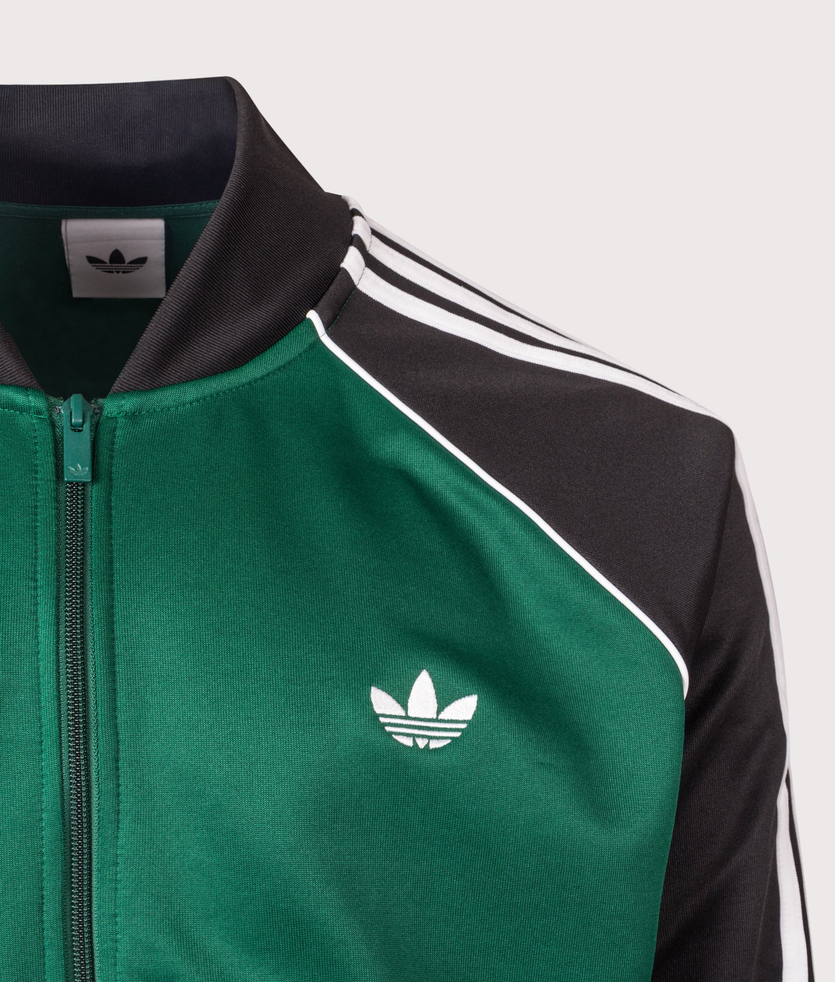 adidas Originals SST Track Top in Collegiate Green at EQVVS Menswear. Detail shot.