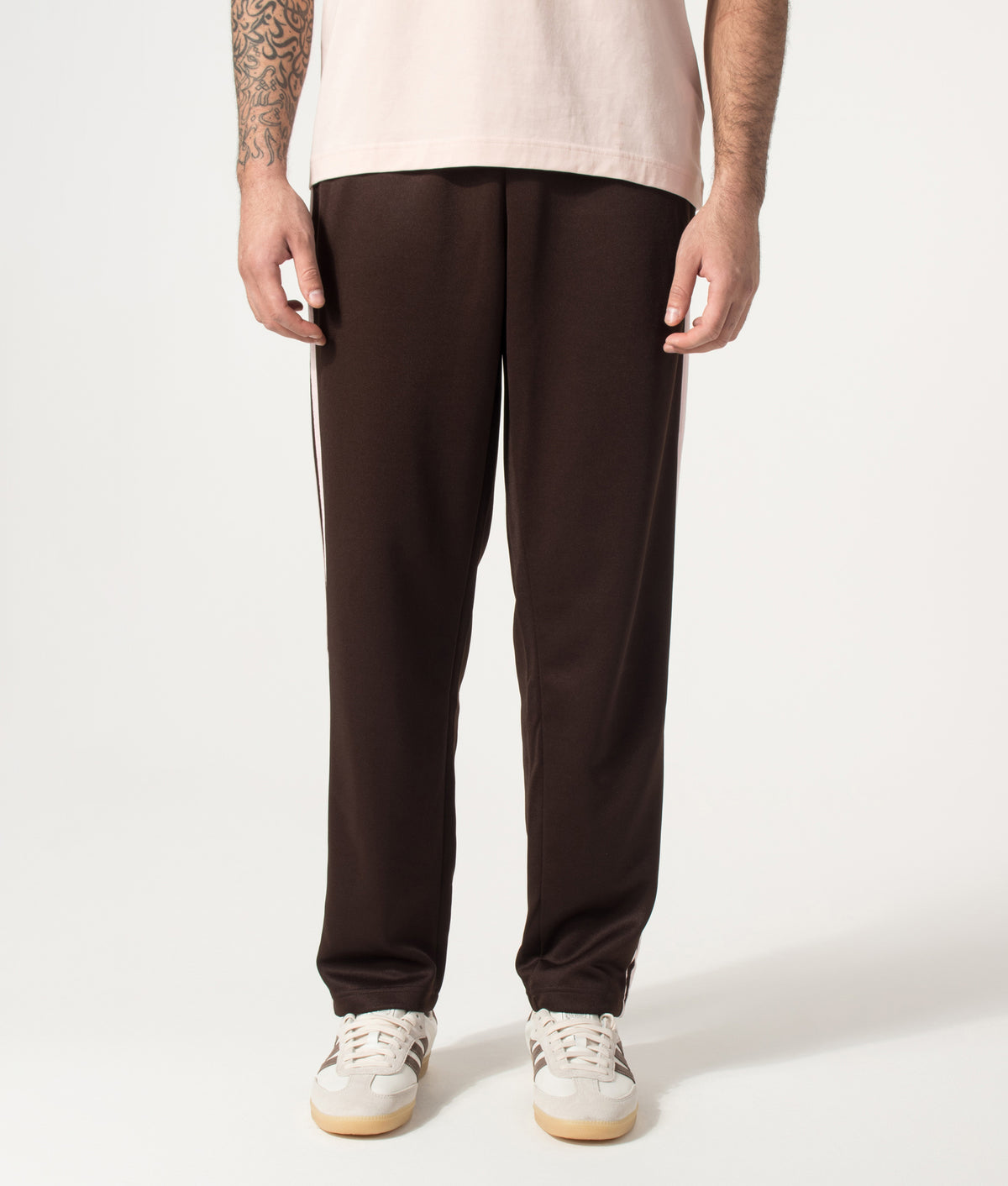 adidas Originals Regular Fit SST Track Pants in Aurora Coffee at EQVVS Menswear. Model front shot. 