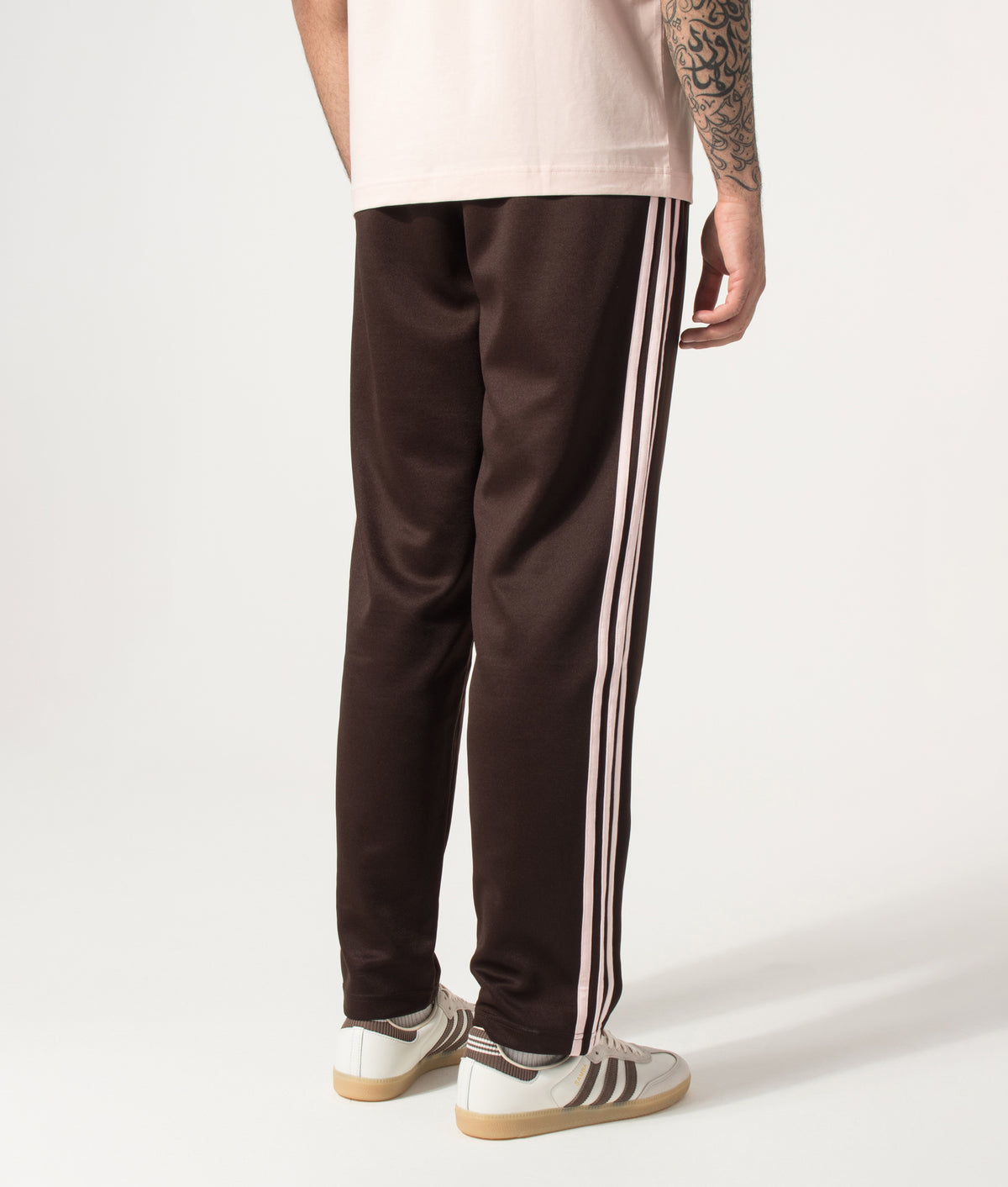 adidas Originals Regular Fit SST Track Pants in Aurora Coffee at EQVVS Menswear. Angled model back shot.