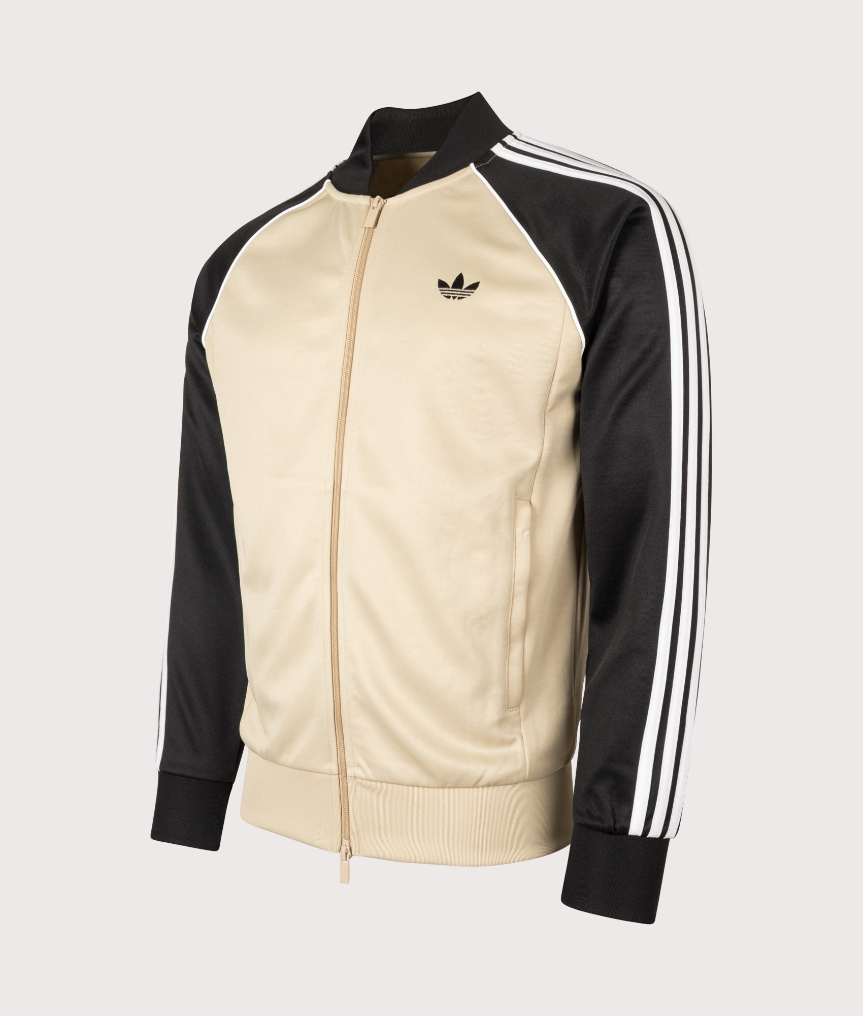 adidas Originals SST Track Top in Stone Khaki at EQVVS Menswear. Angled front shot.