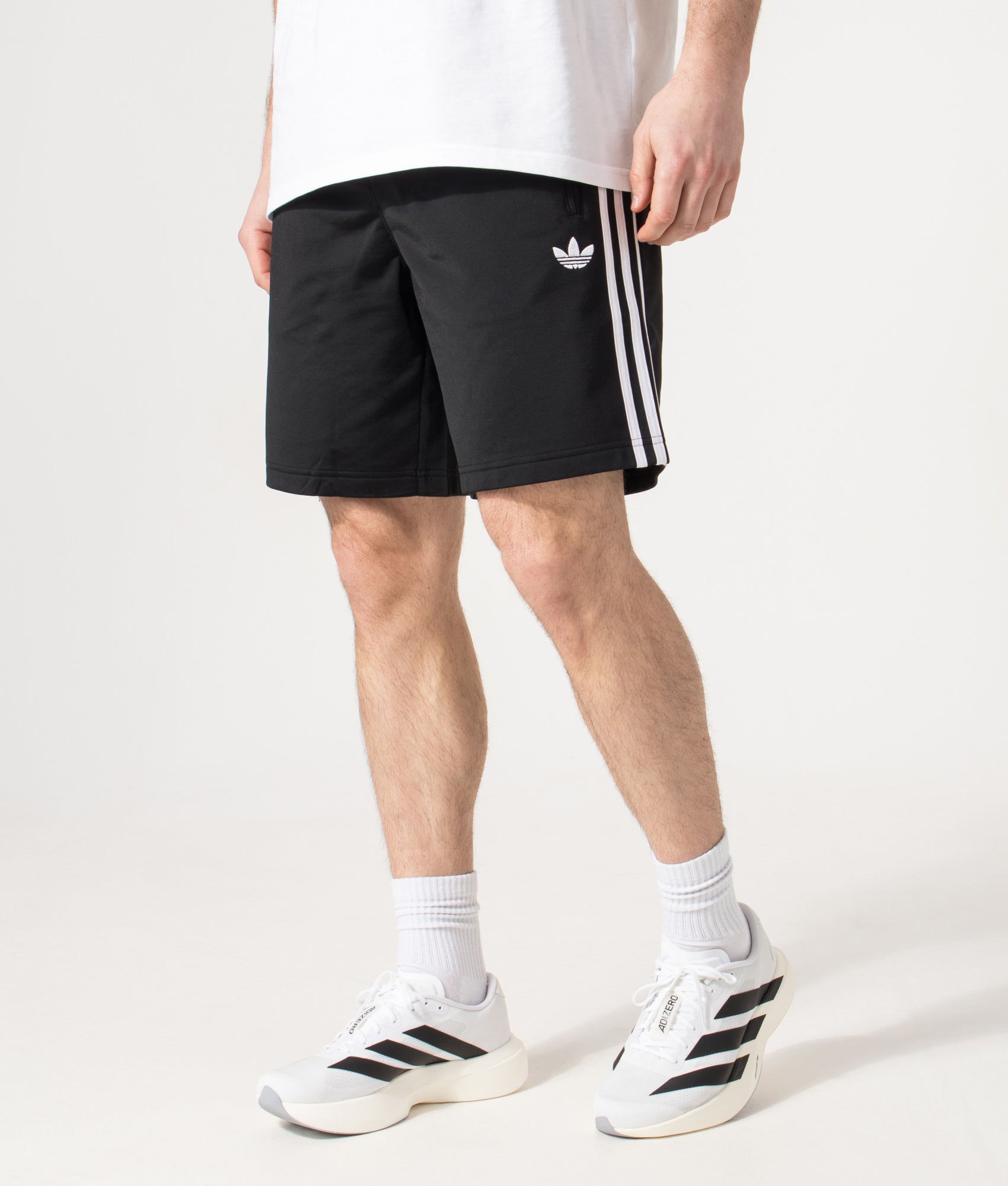 adidas Originals Firebird Shorts in Black at EQVVS Menswear. Model angled front shot.