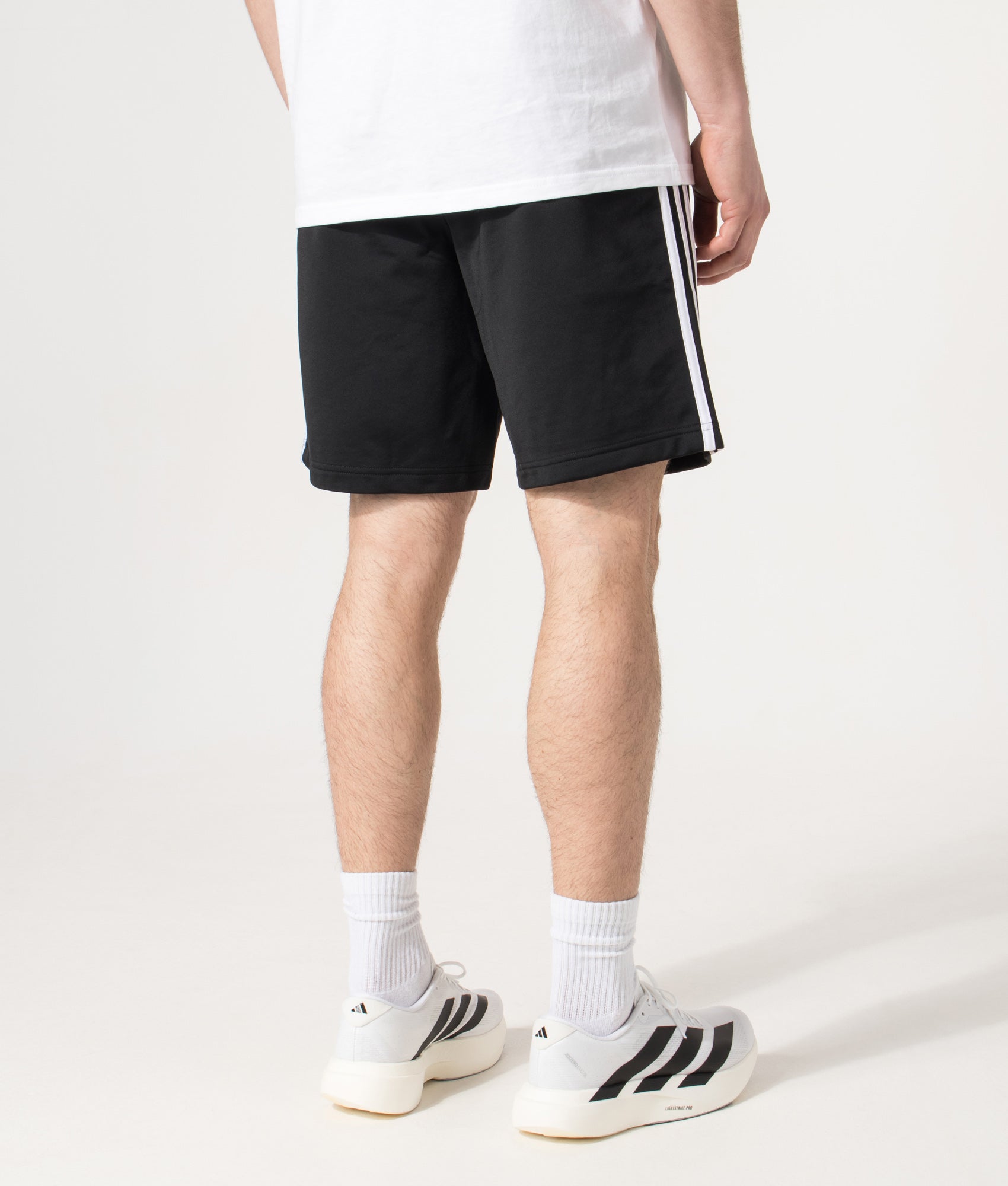 adidas Originals Firebird Shorts in Black at EQVVS Menswear. Angled model back shot.