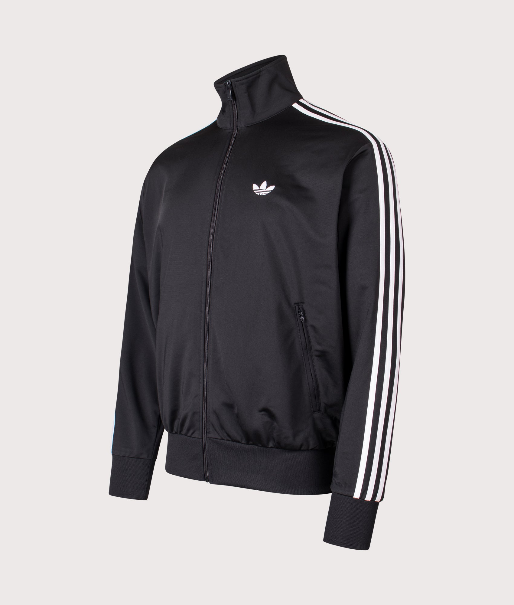 adidas Originals Firebird Track Top in Black at EQVVS Menswear. Angled front shot.