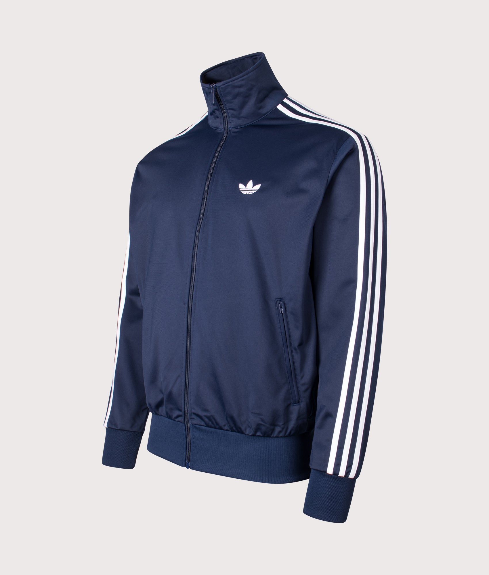 adidas Originals Firebird track top in Night Indigo at EQVVS Menswear. Angled front shot.