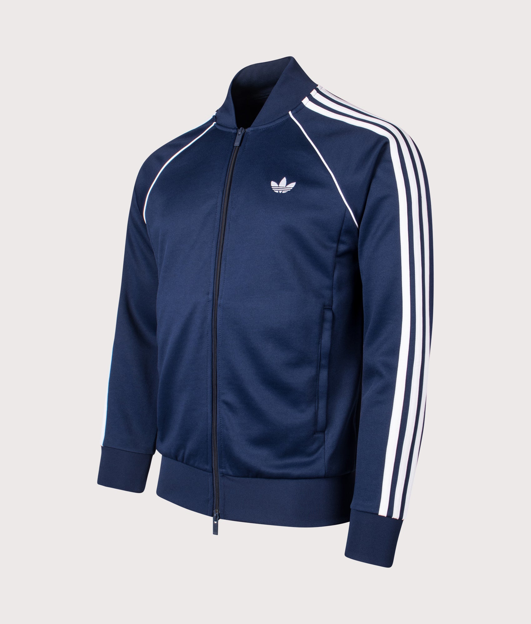 adidas Originals SST Track Top in Night Indigo at EQVVS Menswear. Angled front shot.