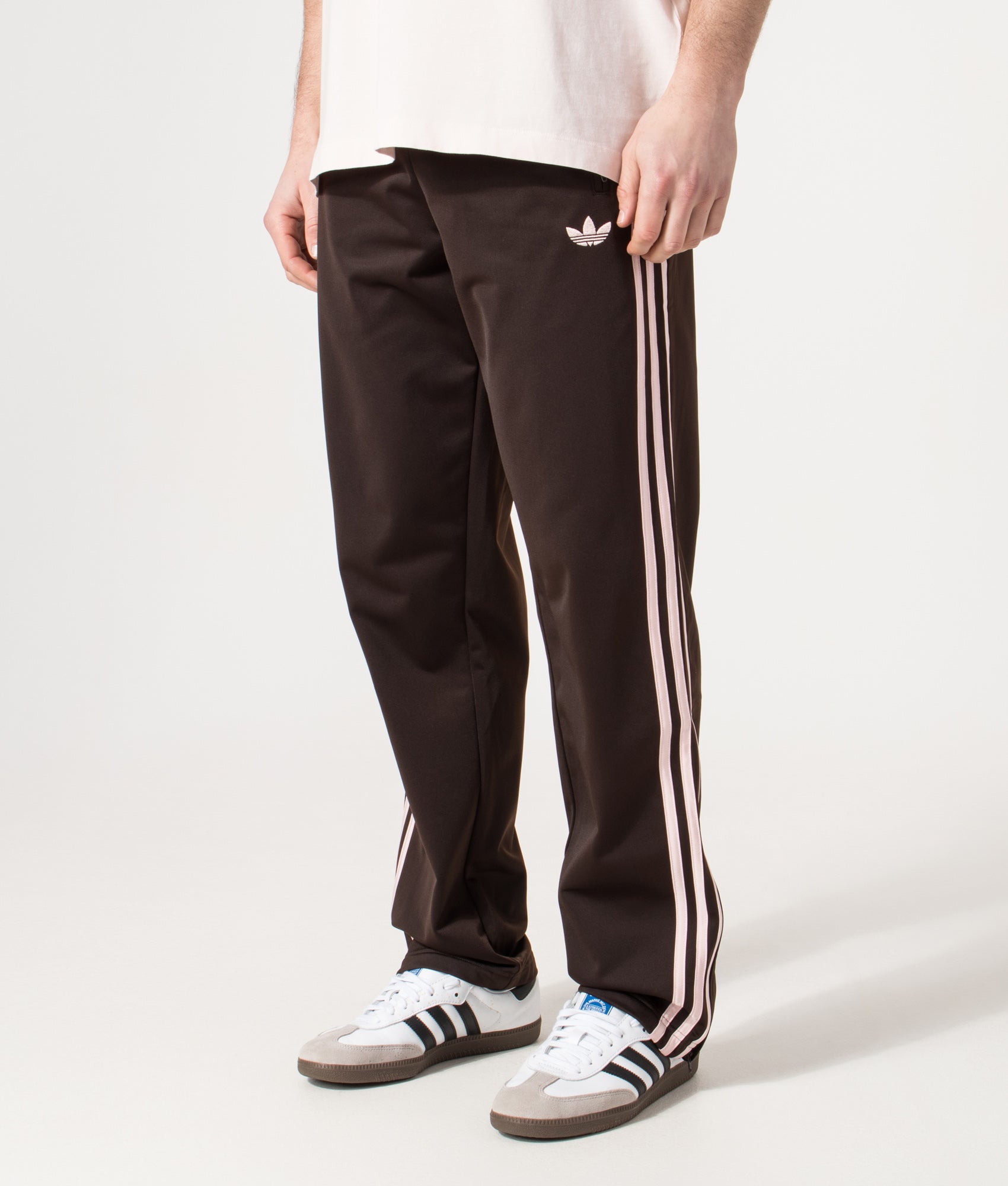adidas Originals Firebird Track Pants in Aurora Coffee at EQVVS Menswear. Angled model front shot.