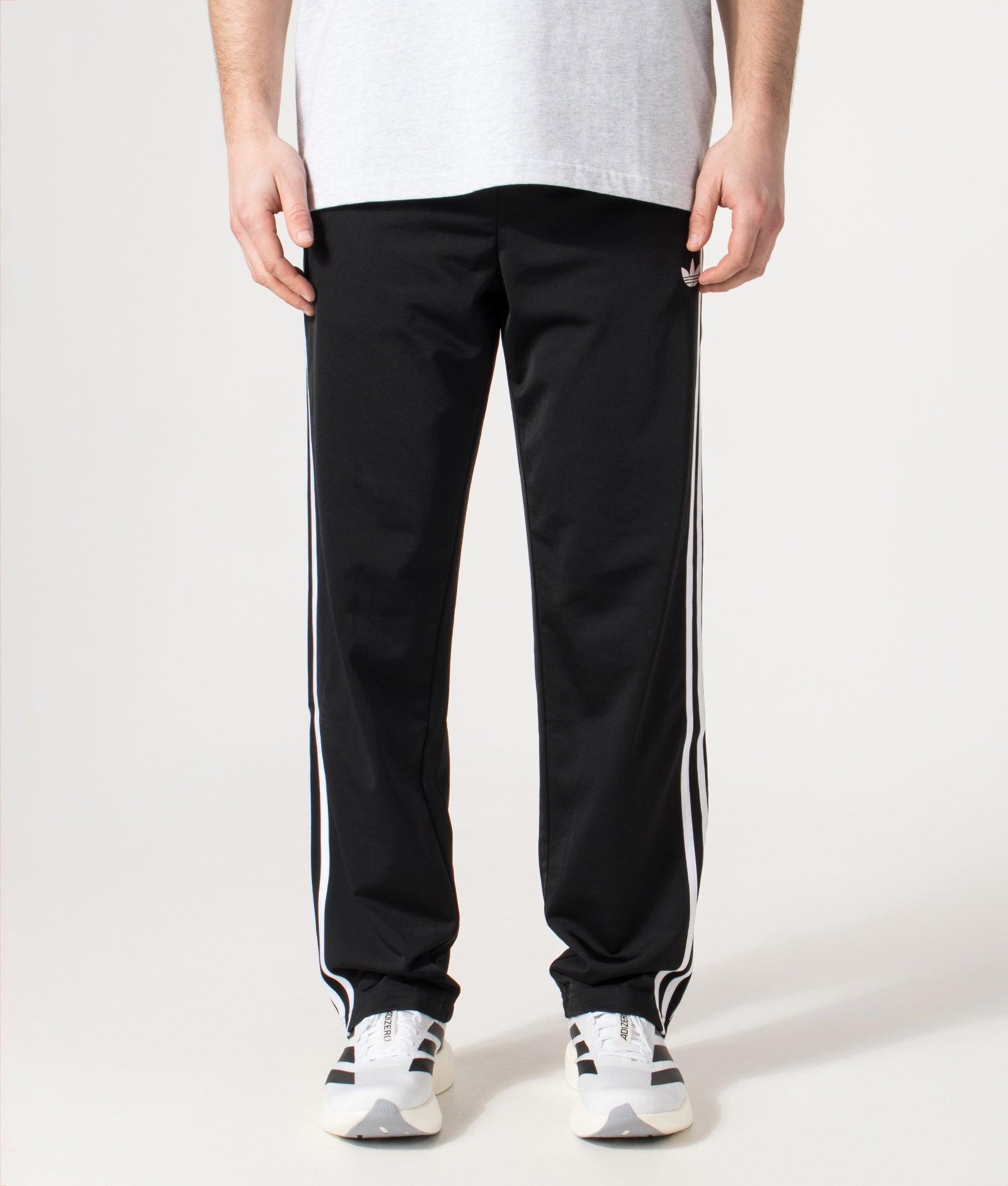 adidas Originals Firebird Track Pants in Black at EQVVS Menswear. Model front shot.