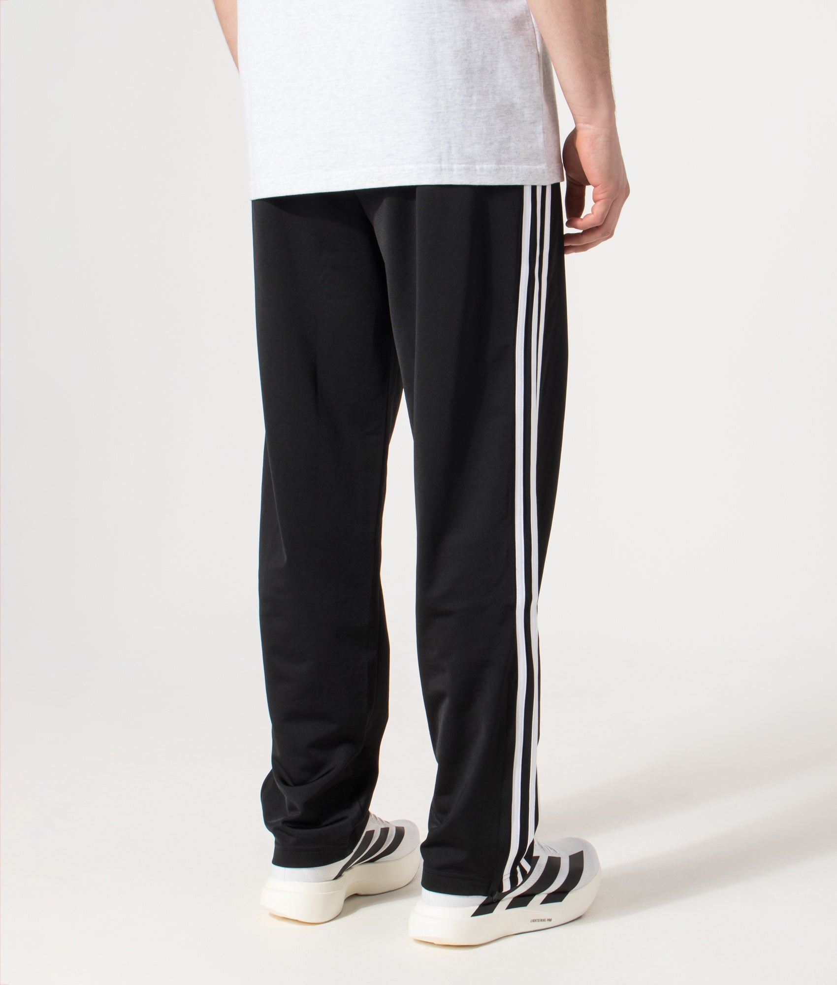 adidas Originals Firebird Track Pants in Black at EQVVS Menswear. Model back shot.
