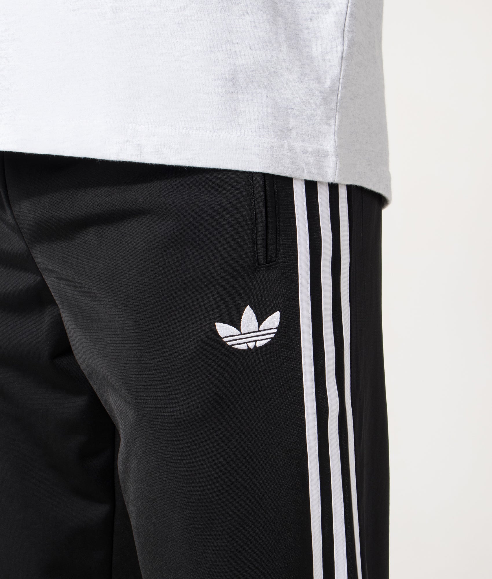 adidas Originals Firebird Track Pants in Black at EQVVS Menswear. Detail shot.