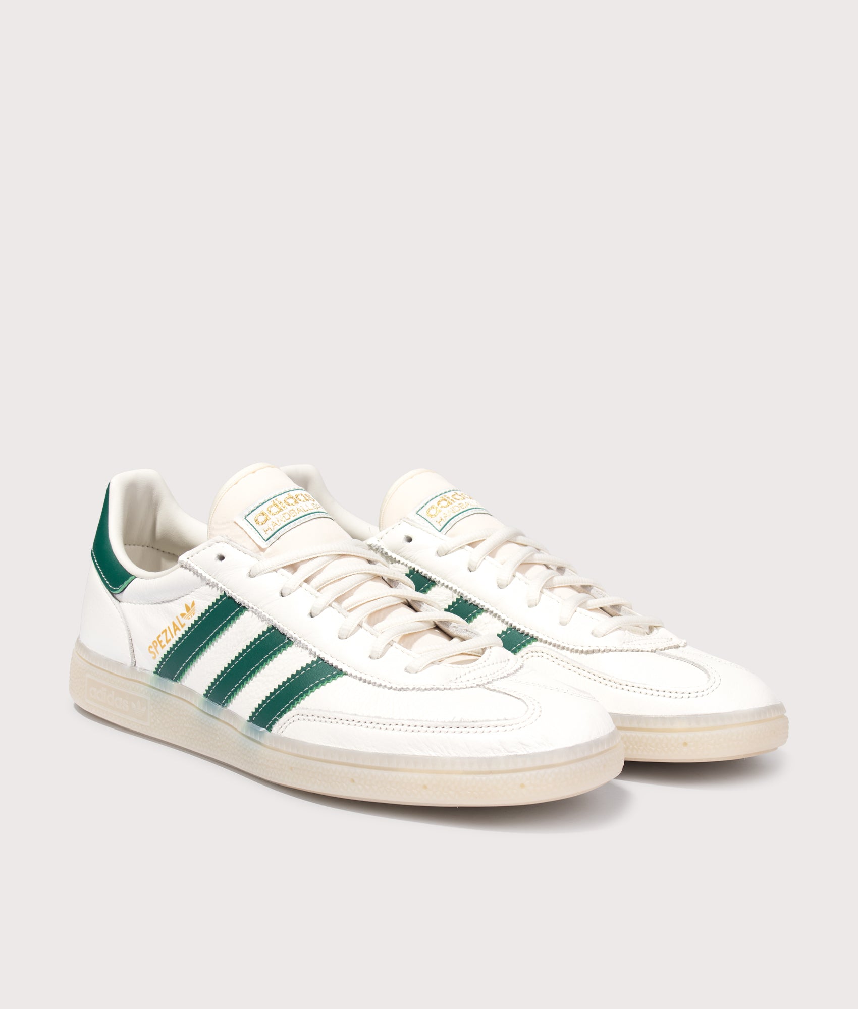adidas Originals Handball Spezial Trainers in Core White, Collegiate Green and Off White at EQVVS Menswear. Angled front shot.