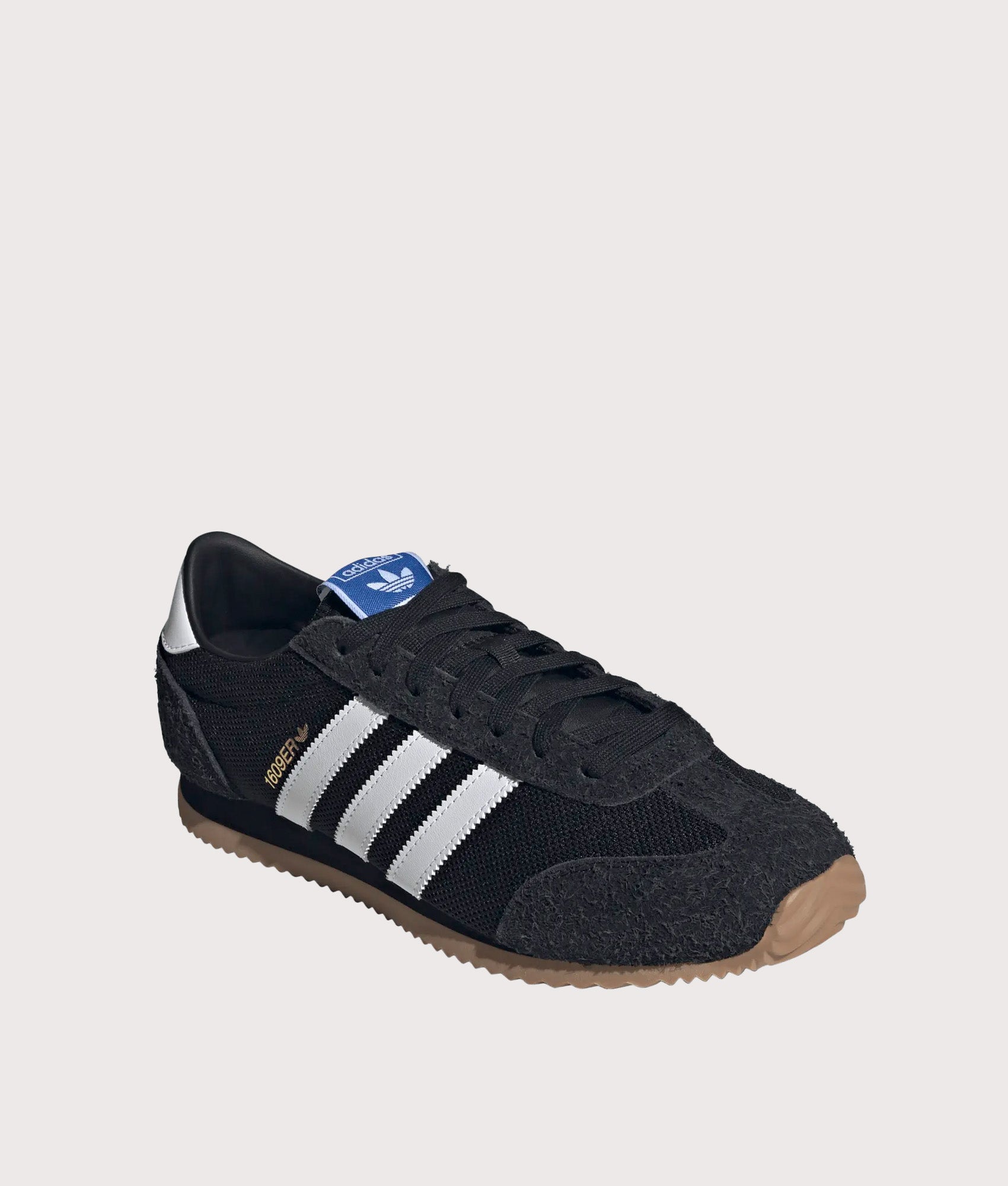 adidas Originals 1609ER RS Trainers in Core Black, Footwear White and Gold Metallic at EQVVS Menswear. Angled front shot.