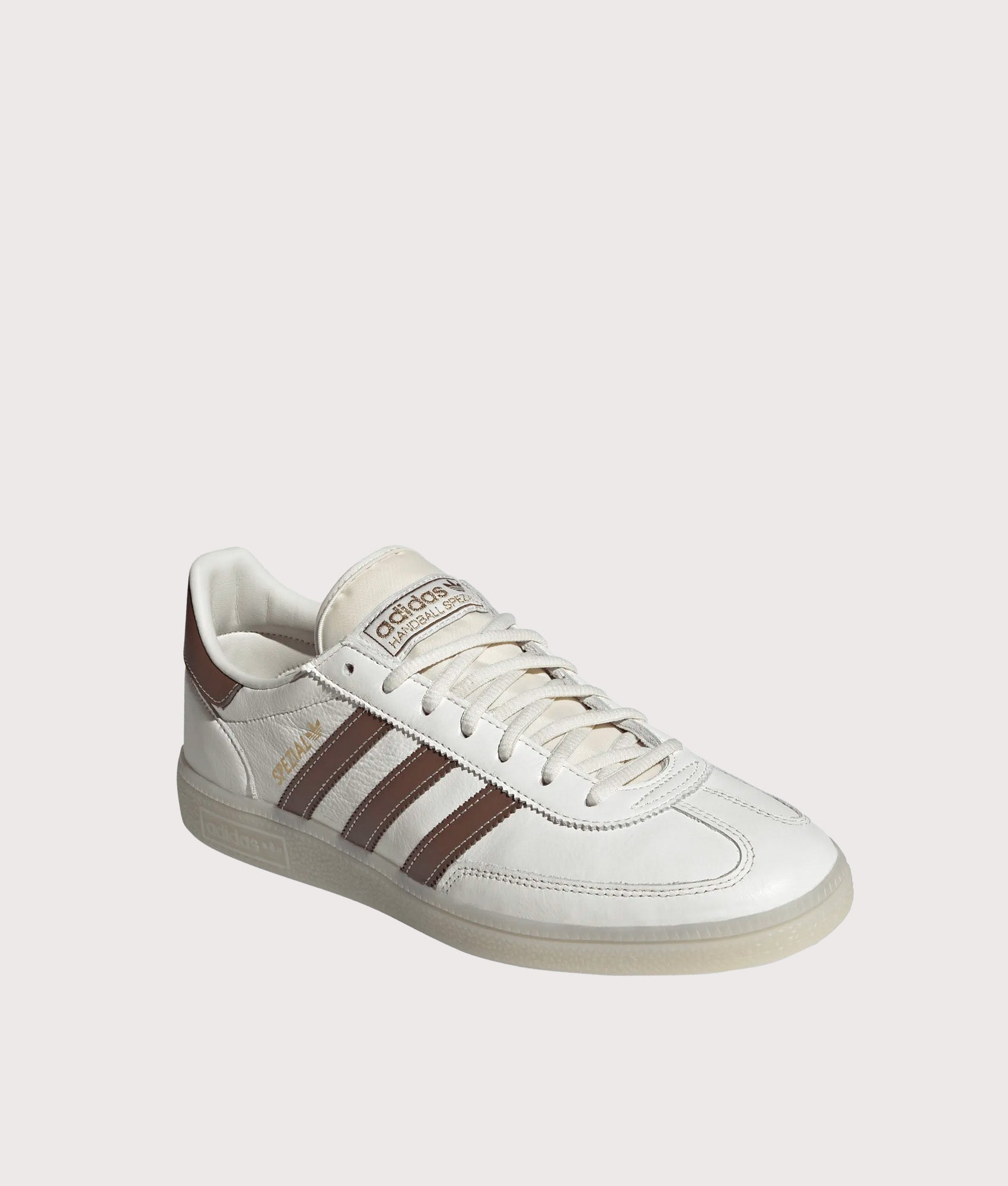 adidas Originals Handball Spezial Trainers in Core White, Preloved Brown and Off White at EQVVS Menswear. Angled front shot.