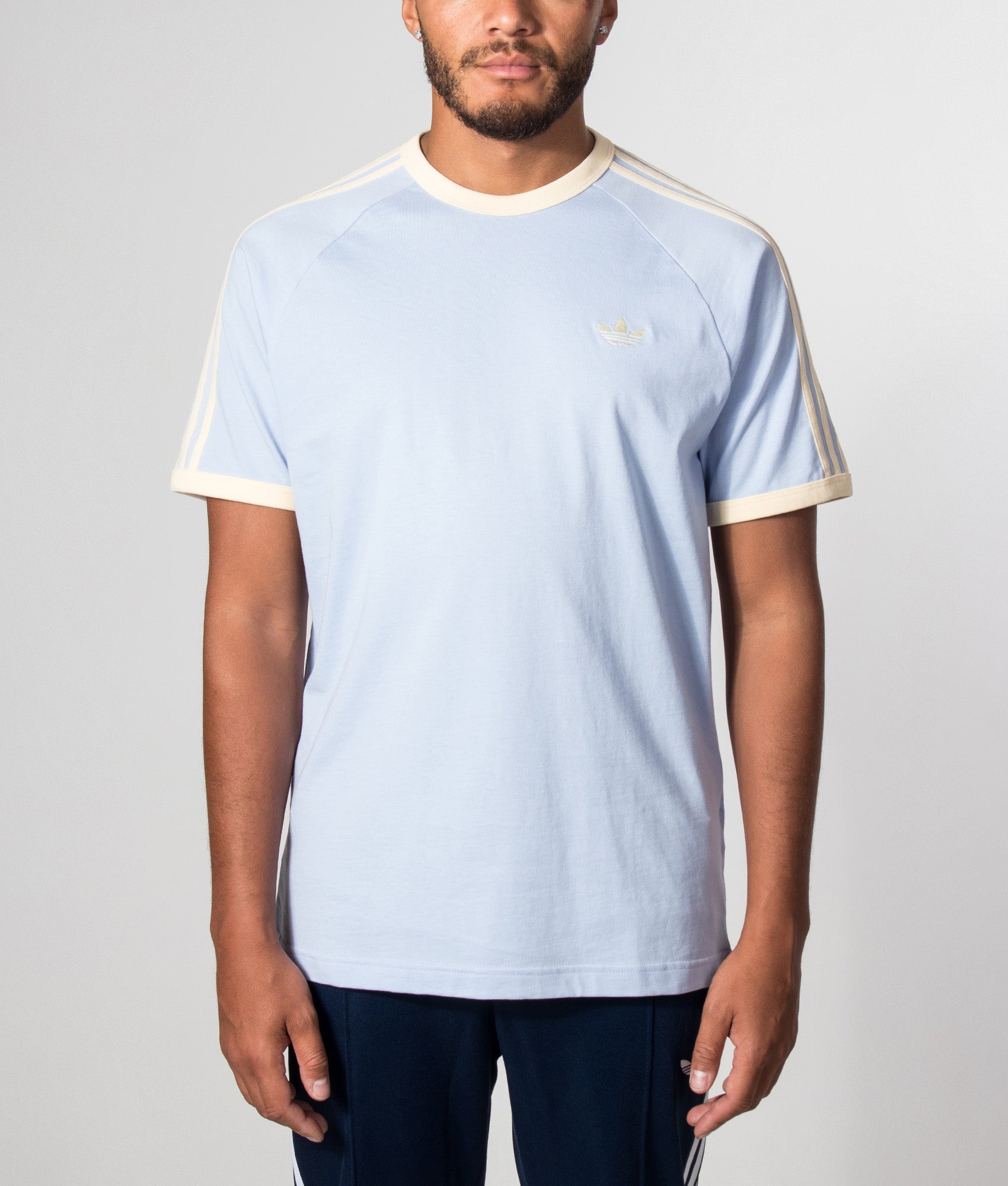 adidas Originals 3 Stripes T-Shirt in Blue Dawn and Warm Vanilla at EQVVS Menswear. Model front shot.