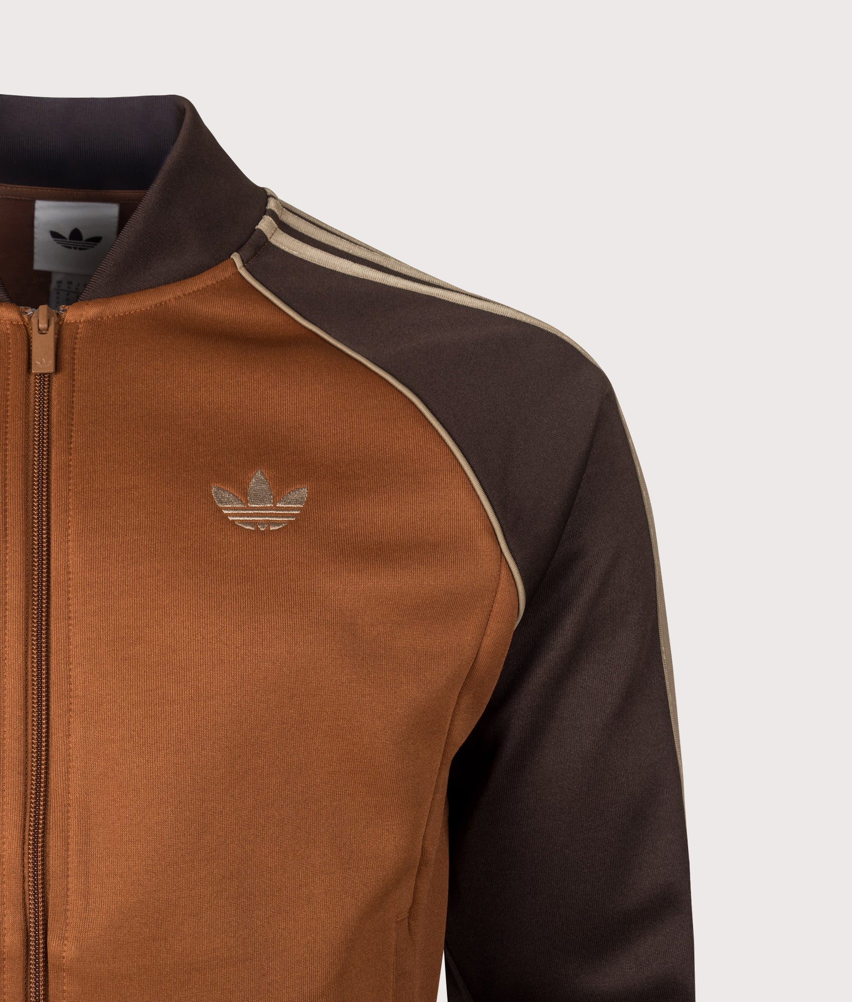 adidas Originals SST Track Top in Dust Brown at EQVVS Menswear. Detail shot.