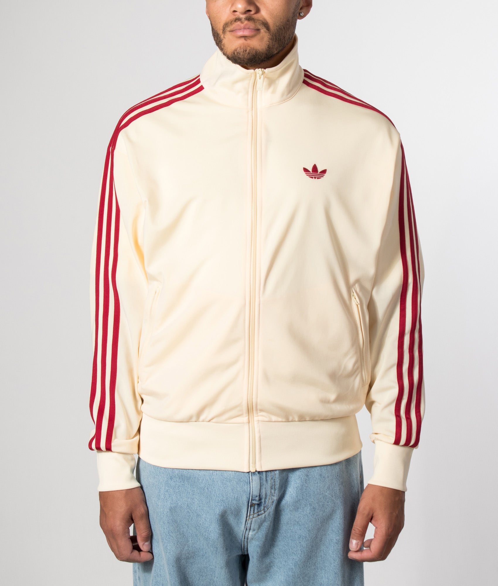 adidas Originals Loose Fit Firebird Track  in Warm Vanilla and Team Victory Red at EQVVS Menswear. Model front shot.