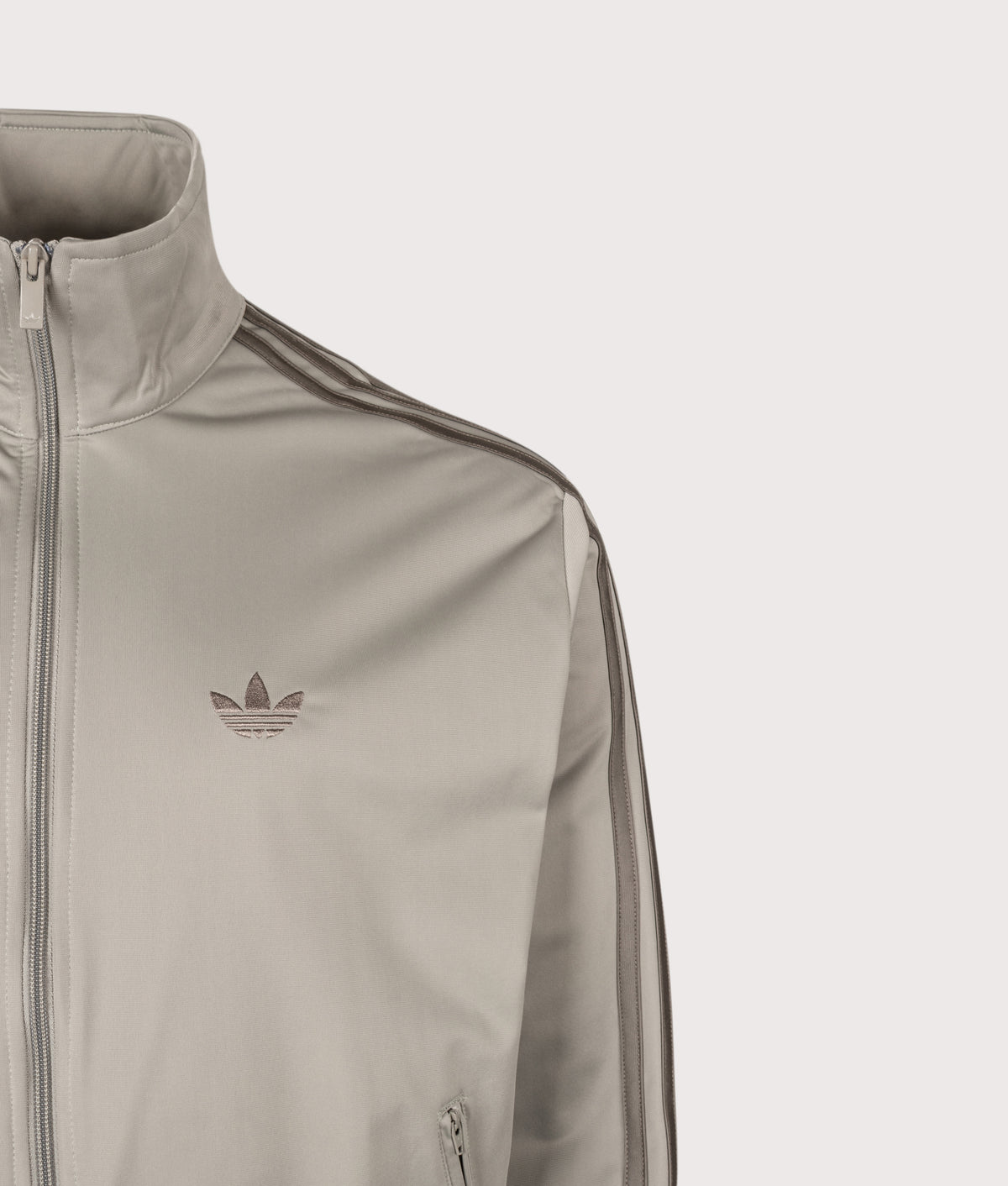 adidas Originals Loose Fit Firebird Track Top in Silver Pebble at EQVVS Menswear. Detail shot.