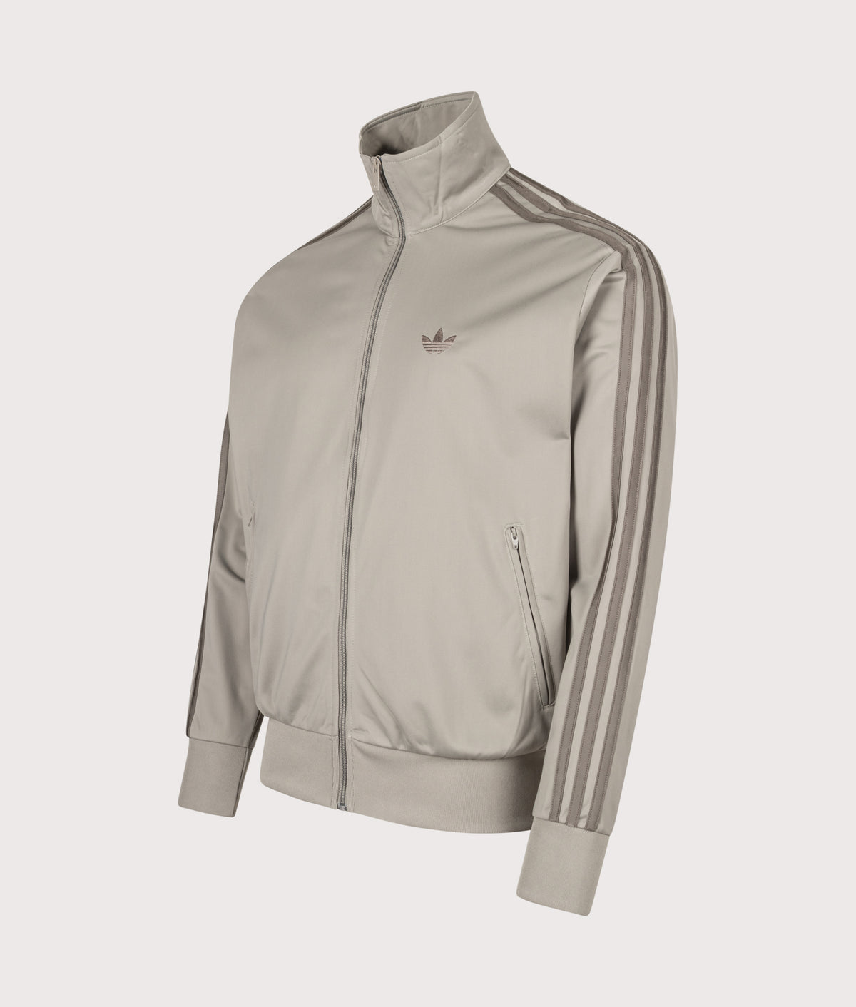 adidas Originals Loose Fit Firebird Track Top in Silver Pebble at EQVVS Menswear. Angled front shot.