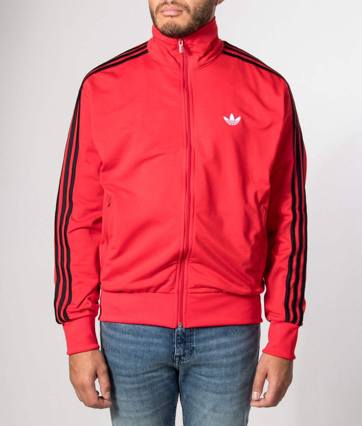adidas Originals Loose Fit Firebird Track Top in Vivid Red at EQVVS Menswear. Model front shot.