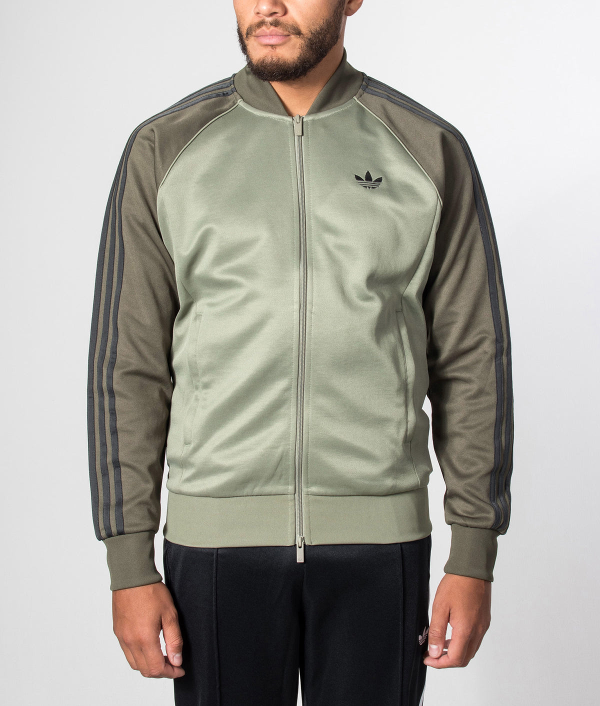 adidas Originals SST Track Top in Silver Pebble at EQVVS Menswear. Model front shot.