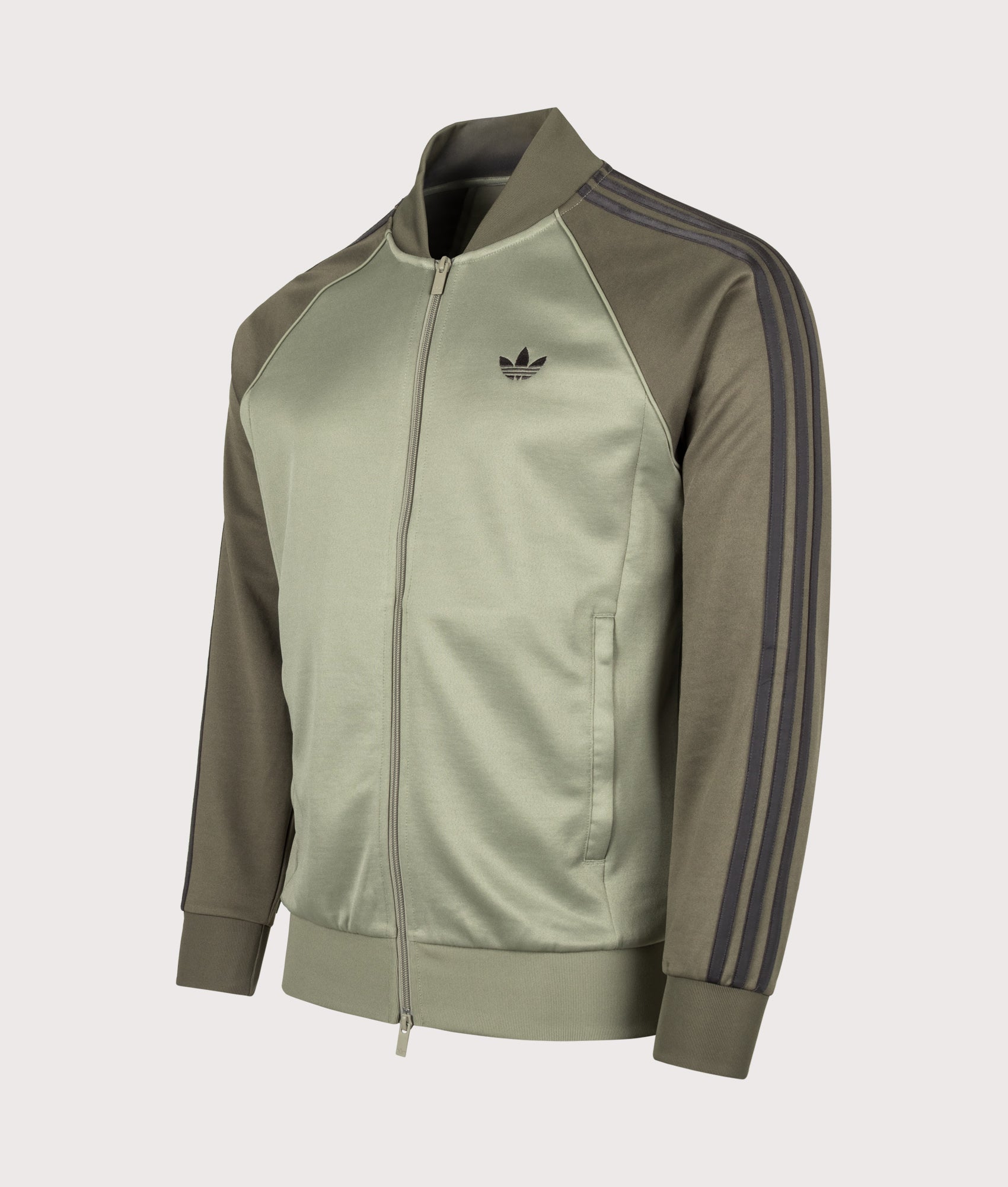 adidas Originals SST Track Top in Silver Pebble at EQVVS Menswear. Angled front shot.