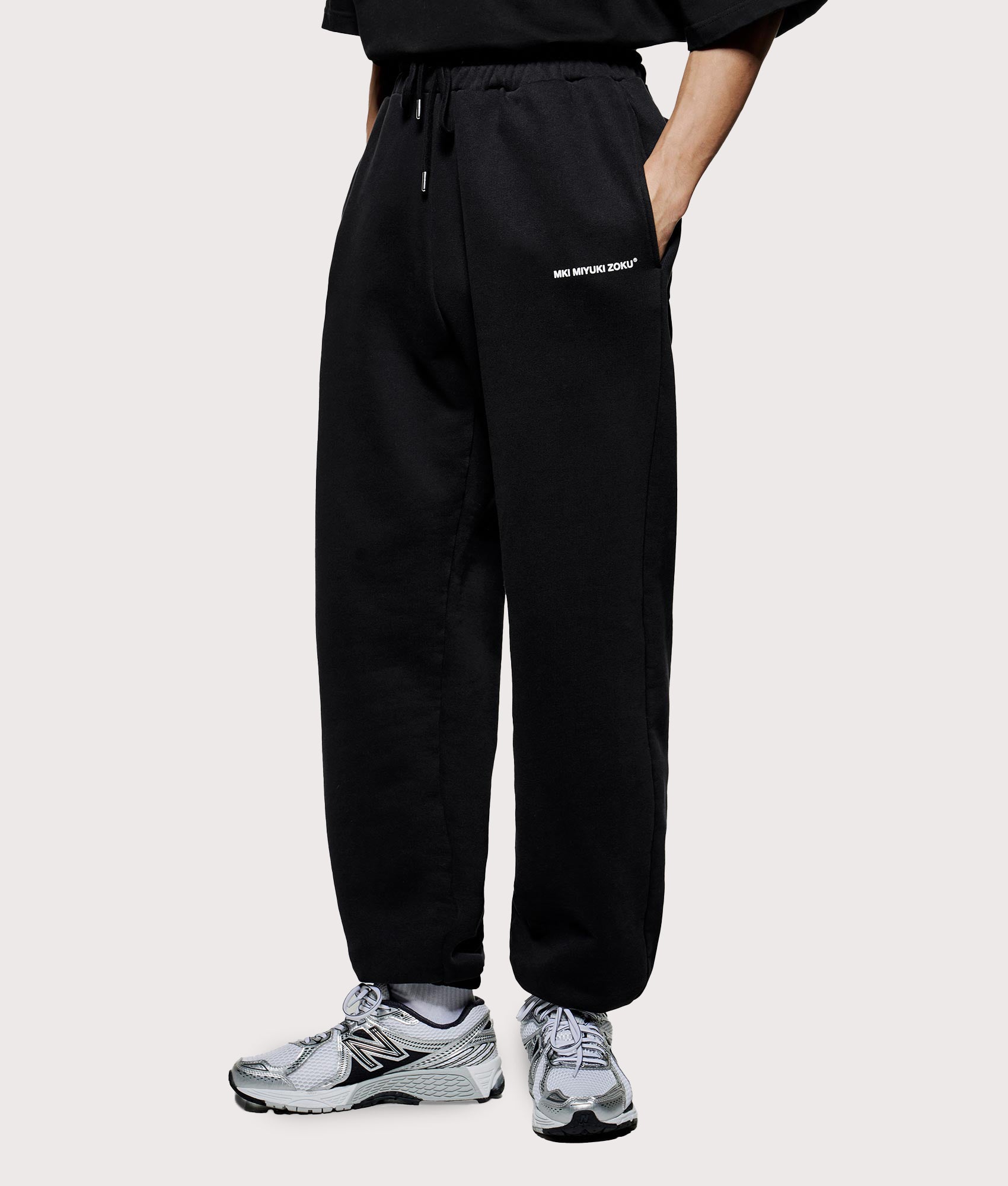 MKI Miyuki Zoku Uniform Joggers in black at EQVVS Menswear. Model angled front shot.