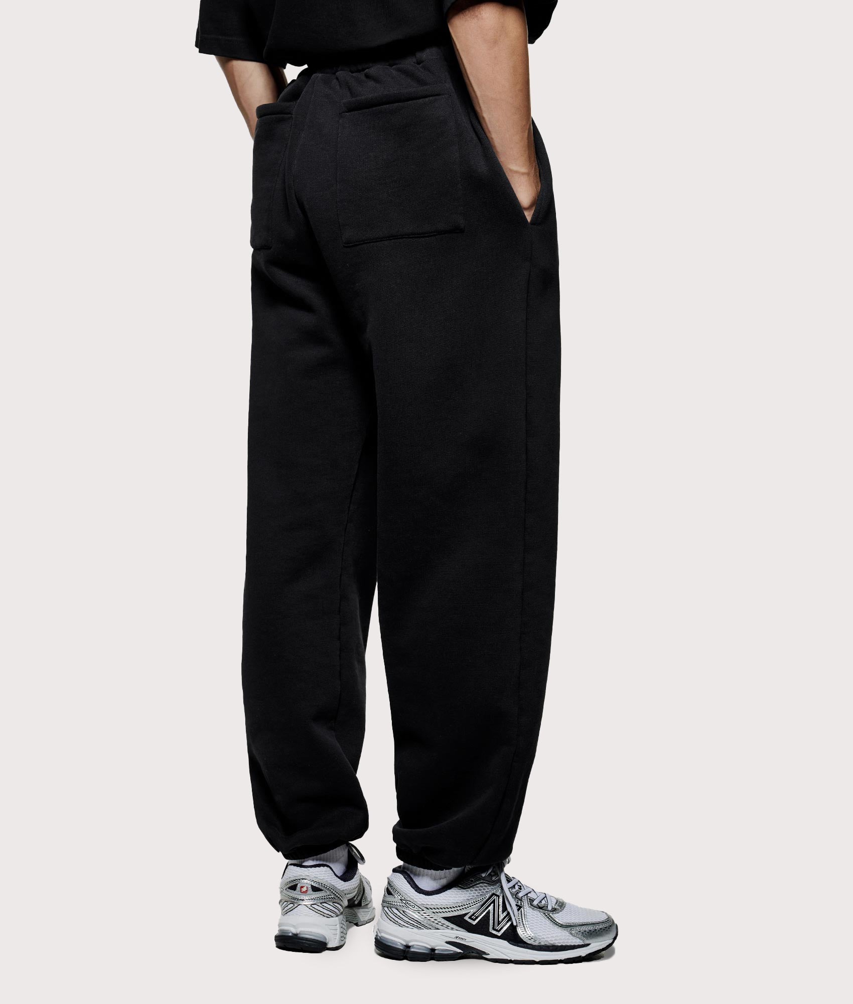 MKI Miyuki Zoku Uniform Joggers in black at EQVVS Menswear. Angled model back shot.
