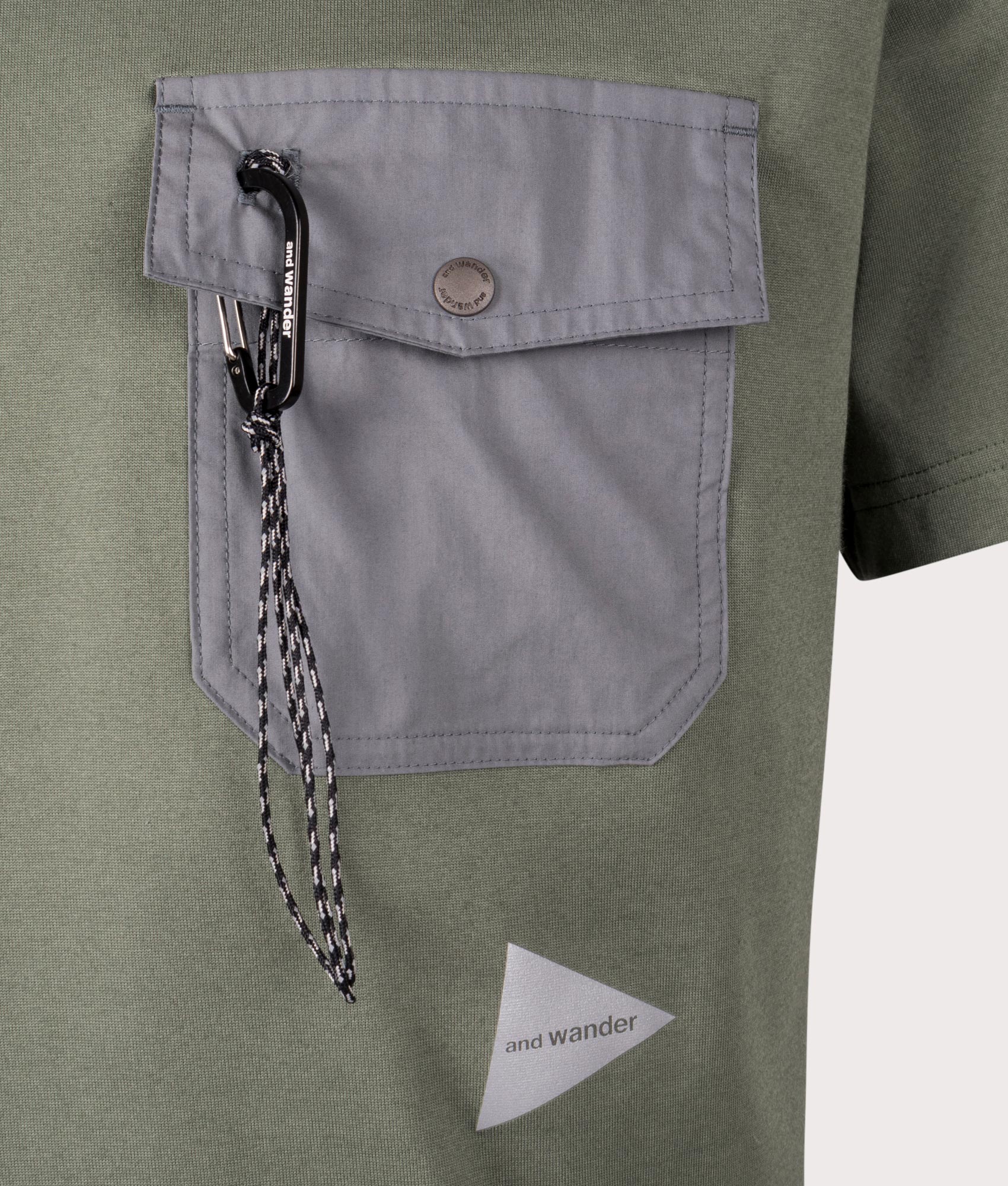 and wander Pocket T-Shirt in Sage. Shot at EQVVS. Front logo shot 
