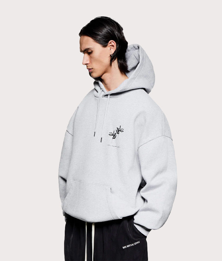 MKI MIYUKI ZOKU Relaxed Fit Ink Flower Hoodie in Grey at EQVVS Menswear. Angled model front shot. 