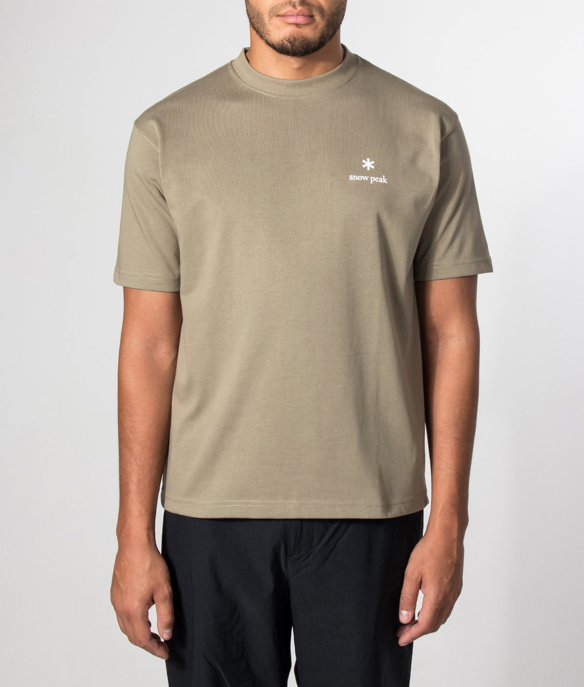 Snow Peak Relaxed Fit New Standard Logo T-Shirt in Dark Beige at EQVVS Menswear. Model front shot.
